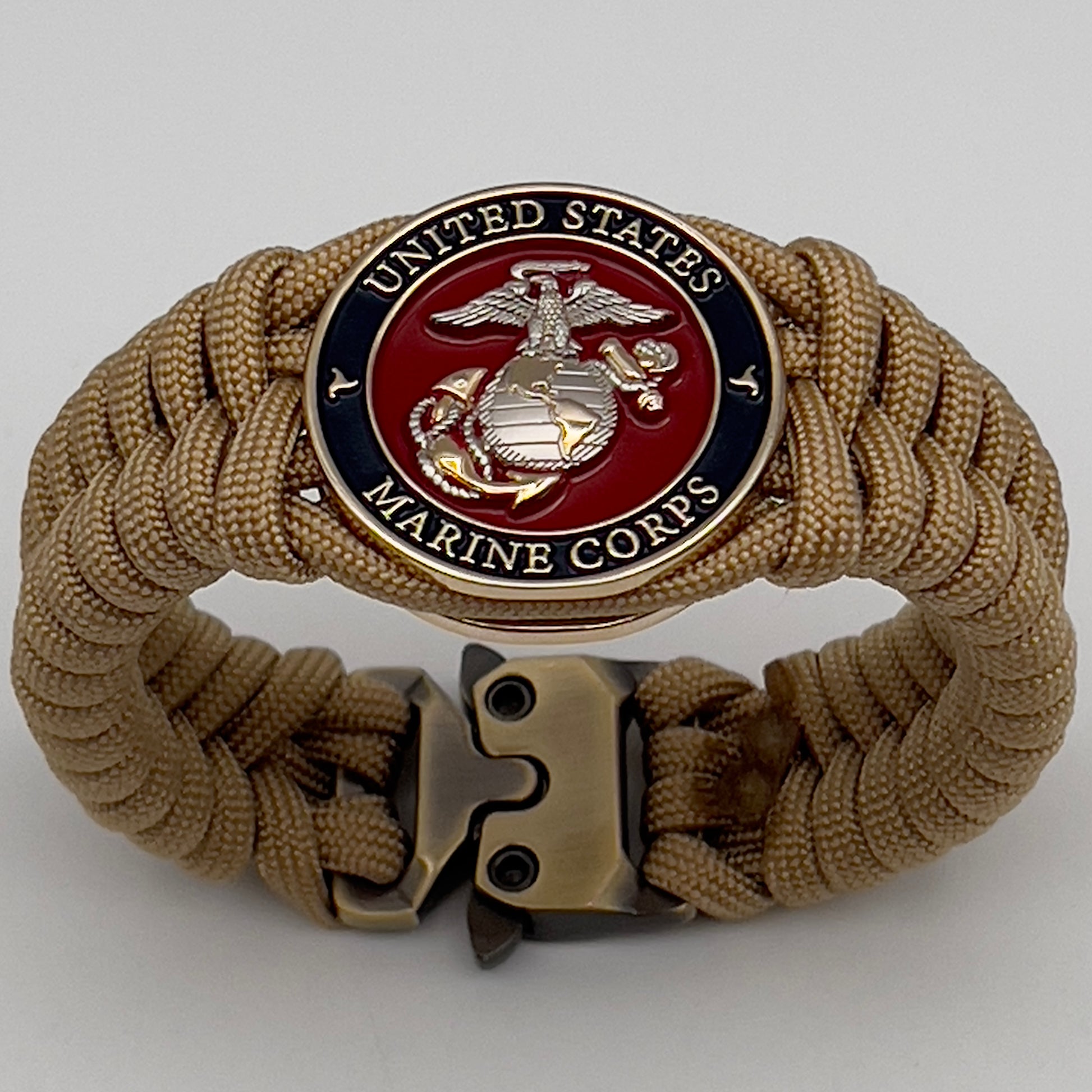 Thick and comfortable braided United States Marine Corps bracelet featuring a 24K gold and silver plated USMC officer Eagle Globe and Anchor medallion, a Cobra style tactical buckle and woven with gold 550 paracord.