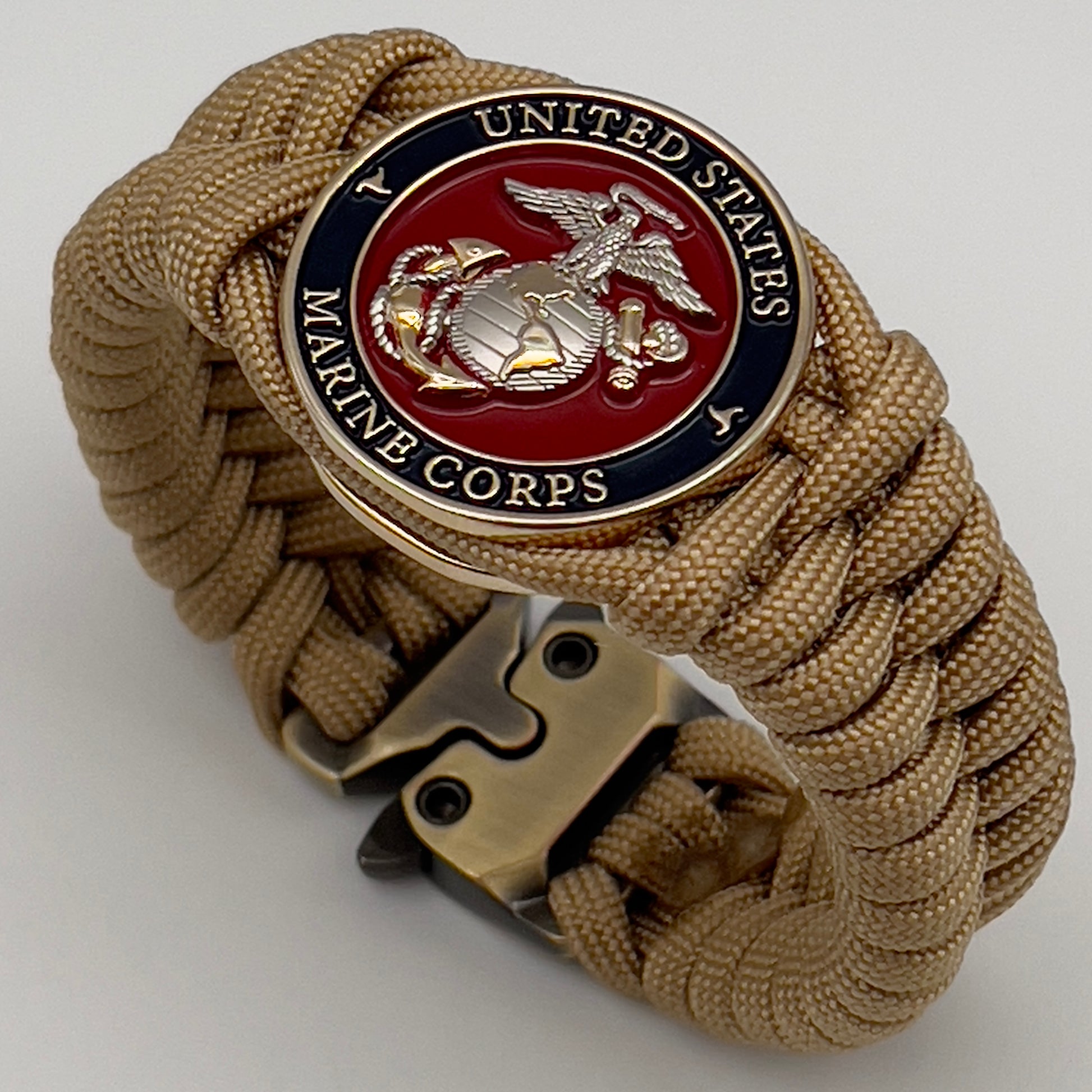 Thick and comfortable braided United States Marine Corps bracelet featuring a 24K gold and silver plated USMC officer Eagle Globe and Anchor medallion, a Cobra style tactical buckle and woven with gold 550 paracord.