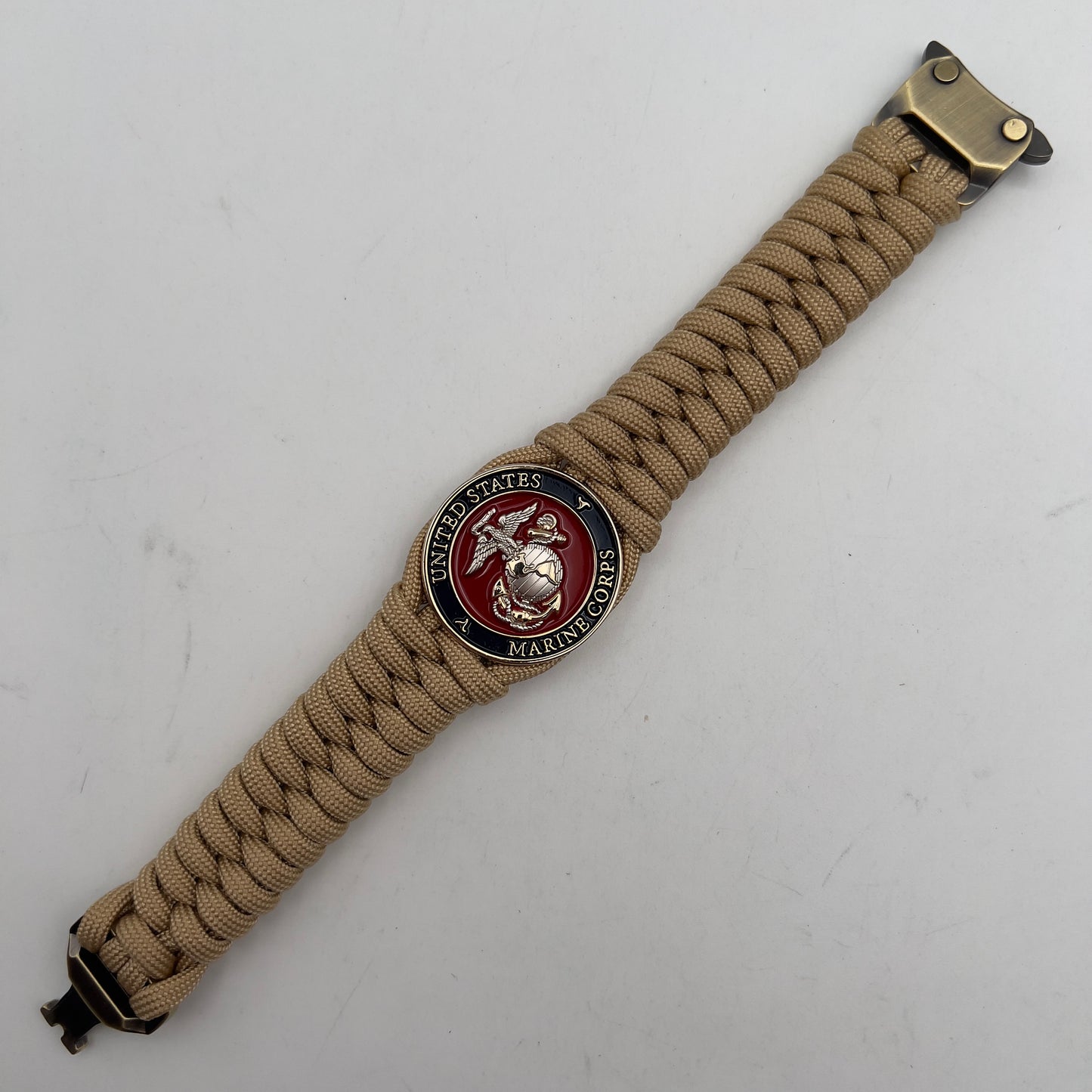 Thick and comfortable braided United States Marine Corps bracelet featuring a 24K gold and silver plated USMC officer Eagle Globe and Anchor medallion, a Cobra style tactical buckle and woven with gold 550 paracord.