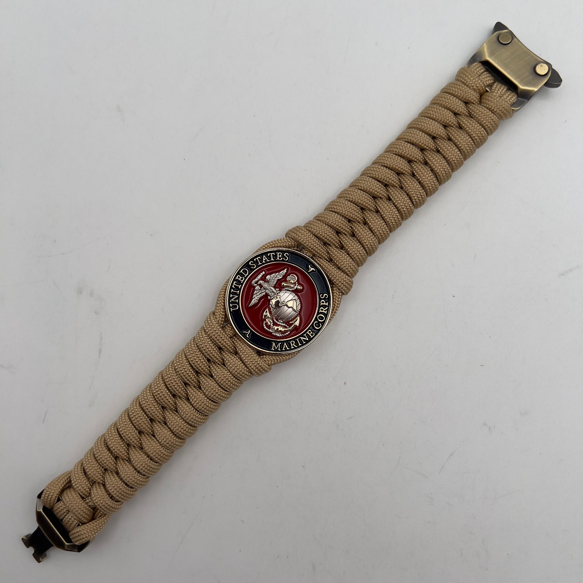 Thick and comfortable braided United States Marine Corps bracelet featuring a 24K gold and silver plated USMC officer Eagle Globe and Anchor medallion, a Cobra style tactical buckle and woven with gold 550 paracord.