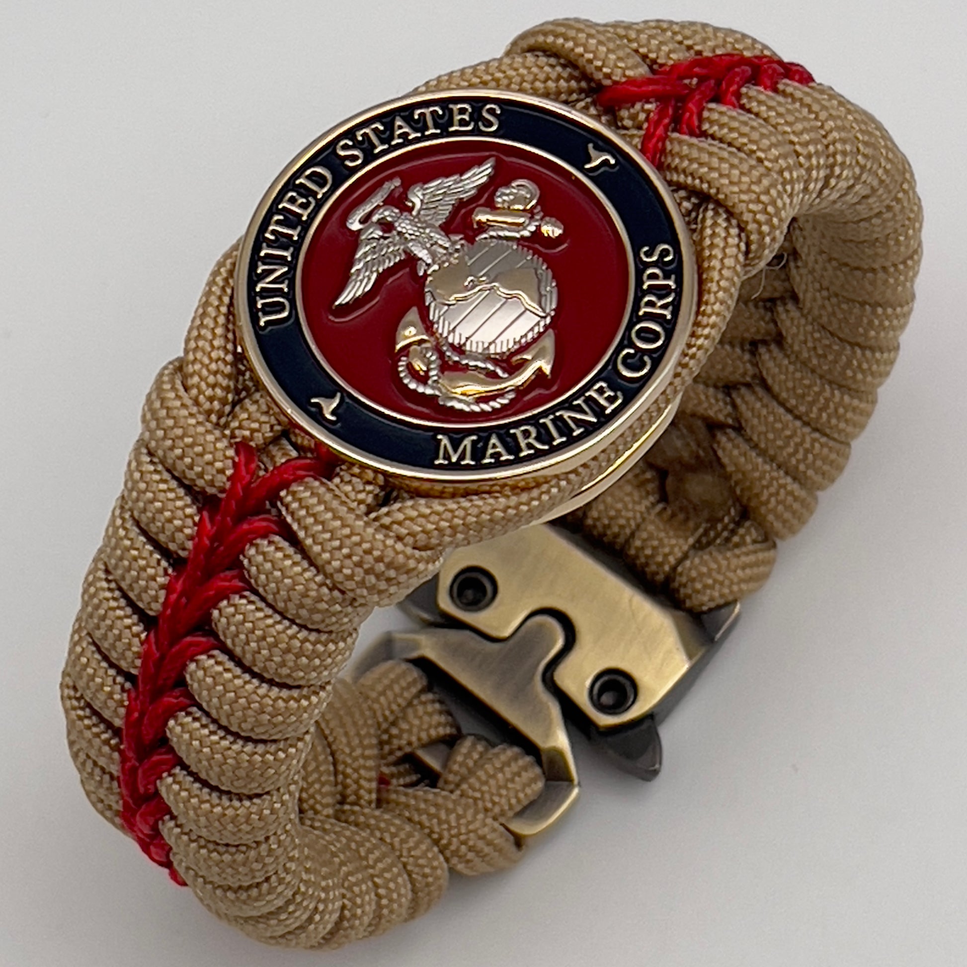 Thick and comfortable braided United States Marine Corps bracelet featuring a 24K gold and silver plated USMC officer Eagle Globe and Anchor medallion, a Cobra style tactical buckle and woven with gold 550 and Imperial red micro paracord.