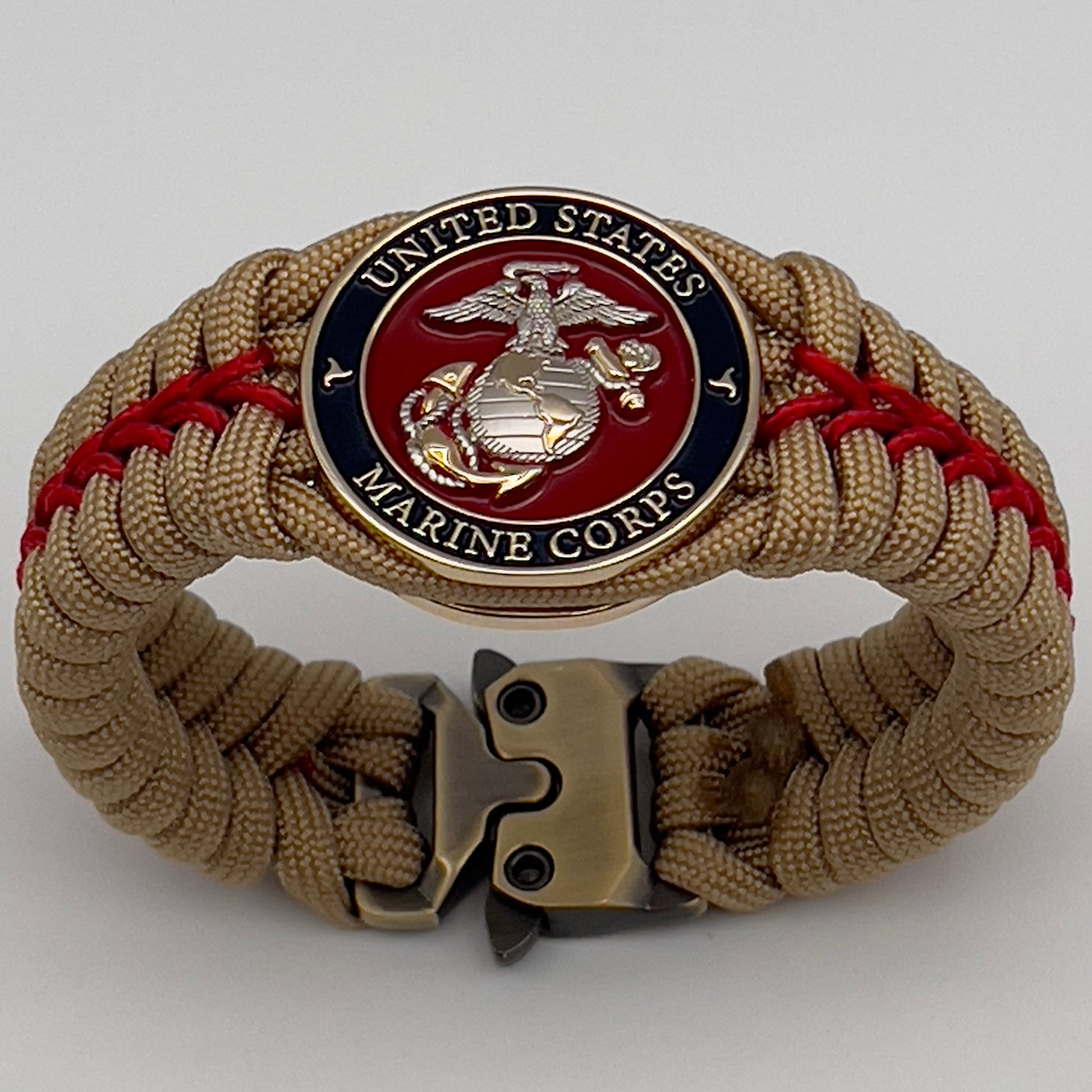 Thick and comfortable braided United States Marine Corps bracelet featuring a 24K gold and silver plated USMC officer Eagle Globe and Anchor medallion, a Cobra style tactical buckle and woven with gold 550 and Imperial red micro paracord.