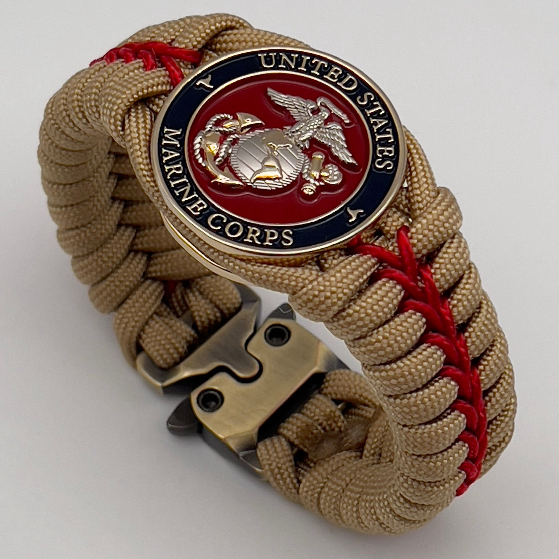 Thick and comfortable braided United States Marine Corps bracelet featuring a 24K gold and silver plated USMC officer Eagle Globe and Anchor medallion, a Cobra style tactical buckle and woven with gold 550 and Imperial red micro paracord.
