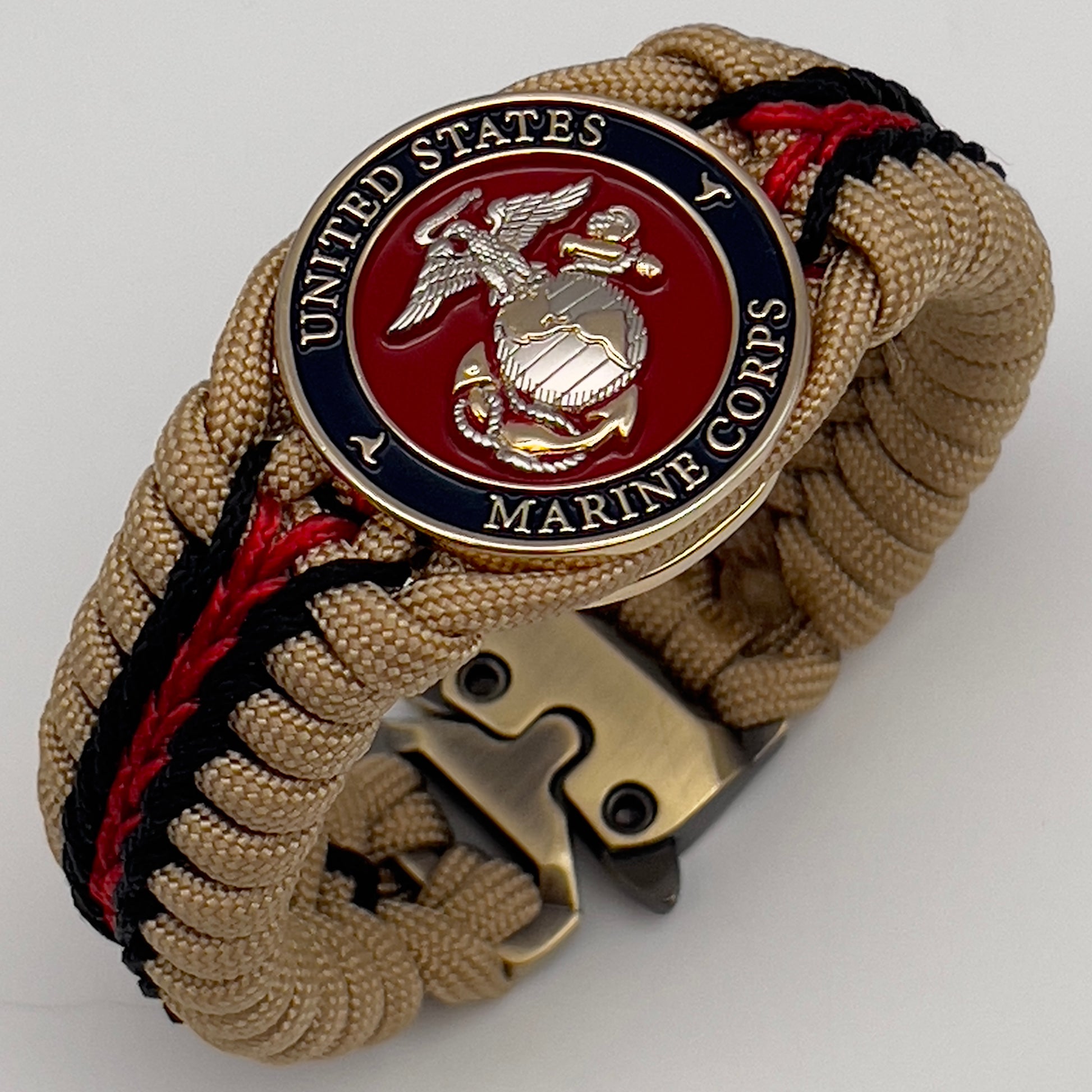 Thick and comfortable braided United States Marine Corps bracelet featuring a 24K gold and silver plated USMC officer Eagle Globe and Anchor medallion, a Cobra style tactical buckle and woven with gold 550 and Imperial red micro paracord.