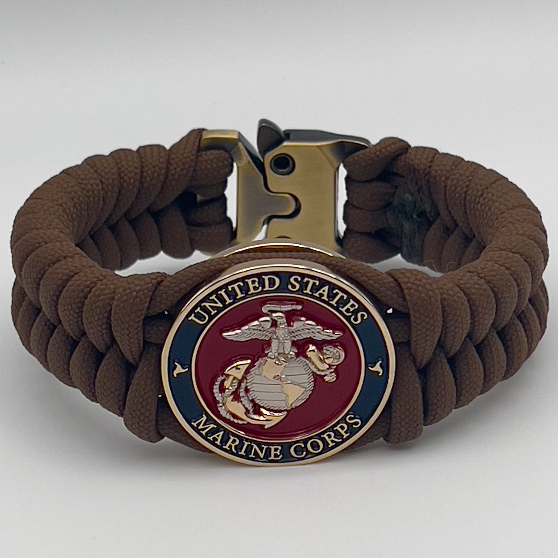 Thick and comfortable braided United States Marine Corps bracelet featuring a 24K gold and silver plated USMC officer Eagle Globe and Anchor medallion, a Cobra style tactical buckle and woven with Coyote brown 550 paracord.