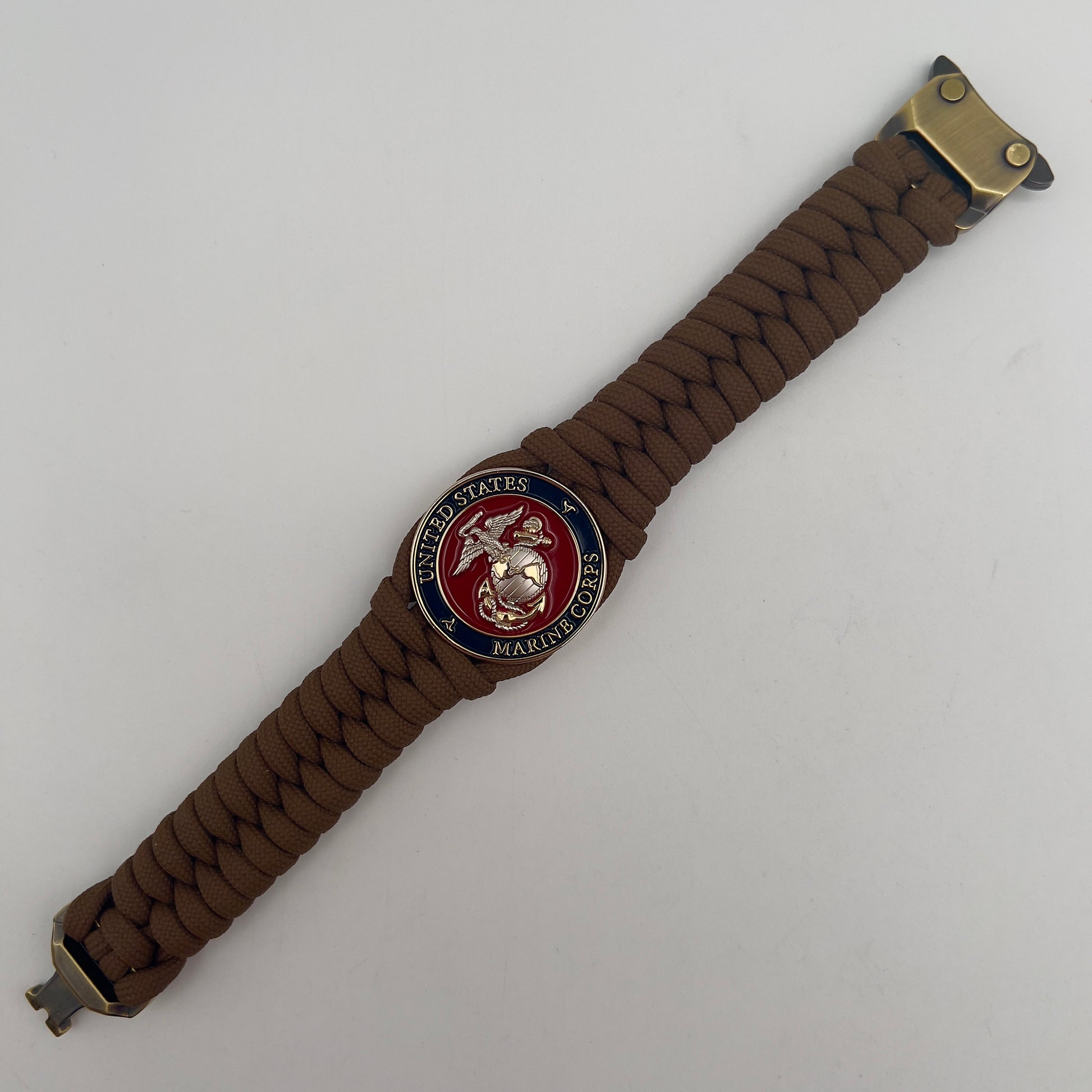 Thick and comfortable braided United States Marine Corps bracelet featuring a 24K gold and silver plated USMC officer Eagle Globe and Anchor medallion, a Cobra style tactical buckle and woven with Coyote brown 550 paracord.