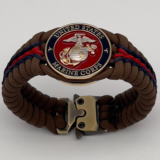 Thick, semi-rigid and comfortable braided United States Marine Corps bracelet featuring a 24K gold and silver plated USMC officer Eagle Globe and Anchor medallion, a Cobra style tactical buckle and woven with Coyote brown 550, Navy blue and Imperial red micro paracord.