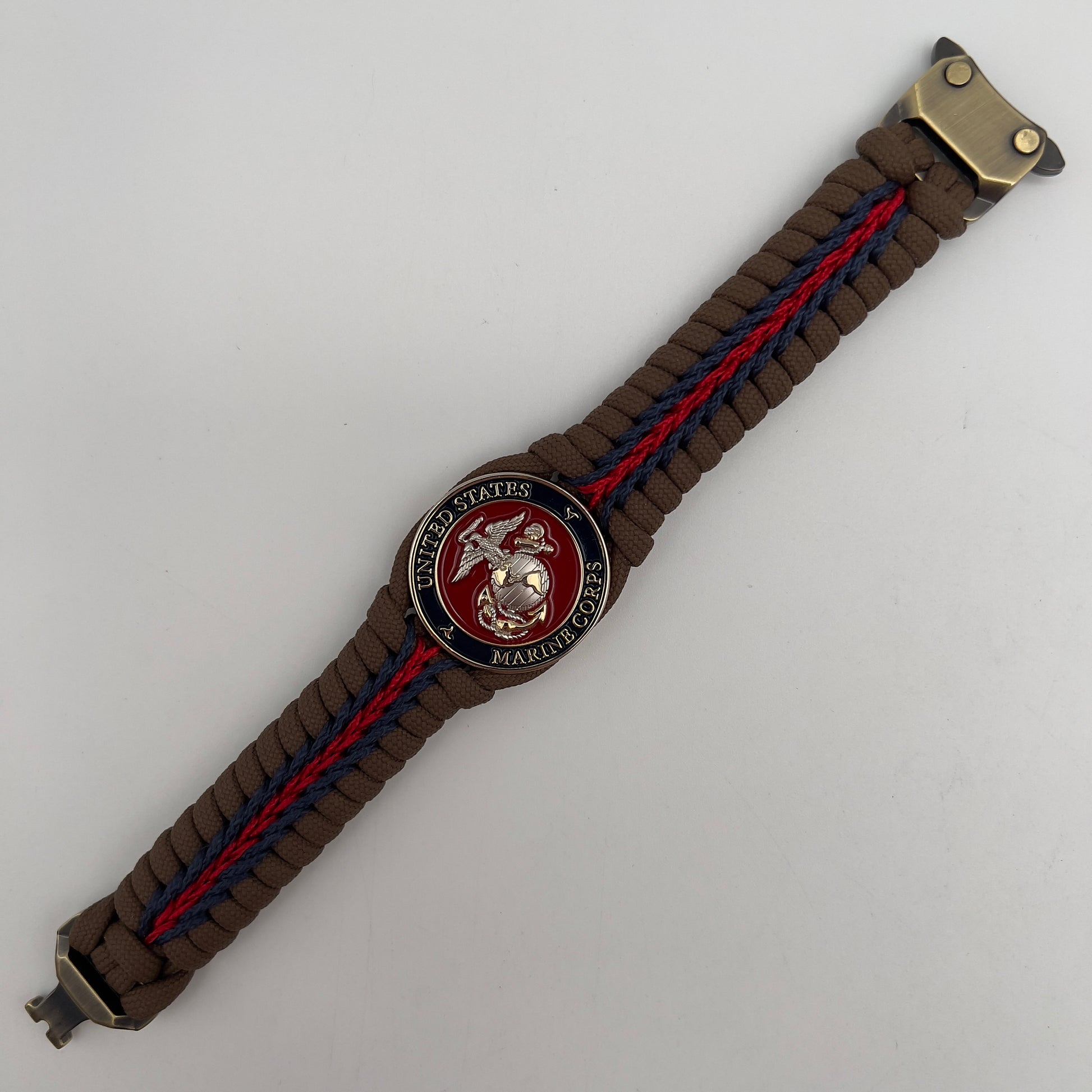 Thick, semi-rigid and comfortable braided United States Marine Corps bracelet featuring a 24K gold and silver plated USMC officer Eagle Globe and Anchor medallion, a Cobra style tactical buckle and woven with Coyote brown 550, Navy blue and Imperial red micro paracord.