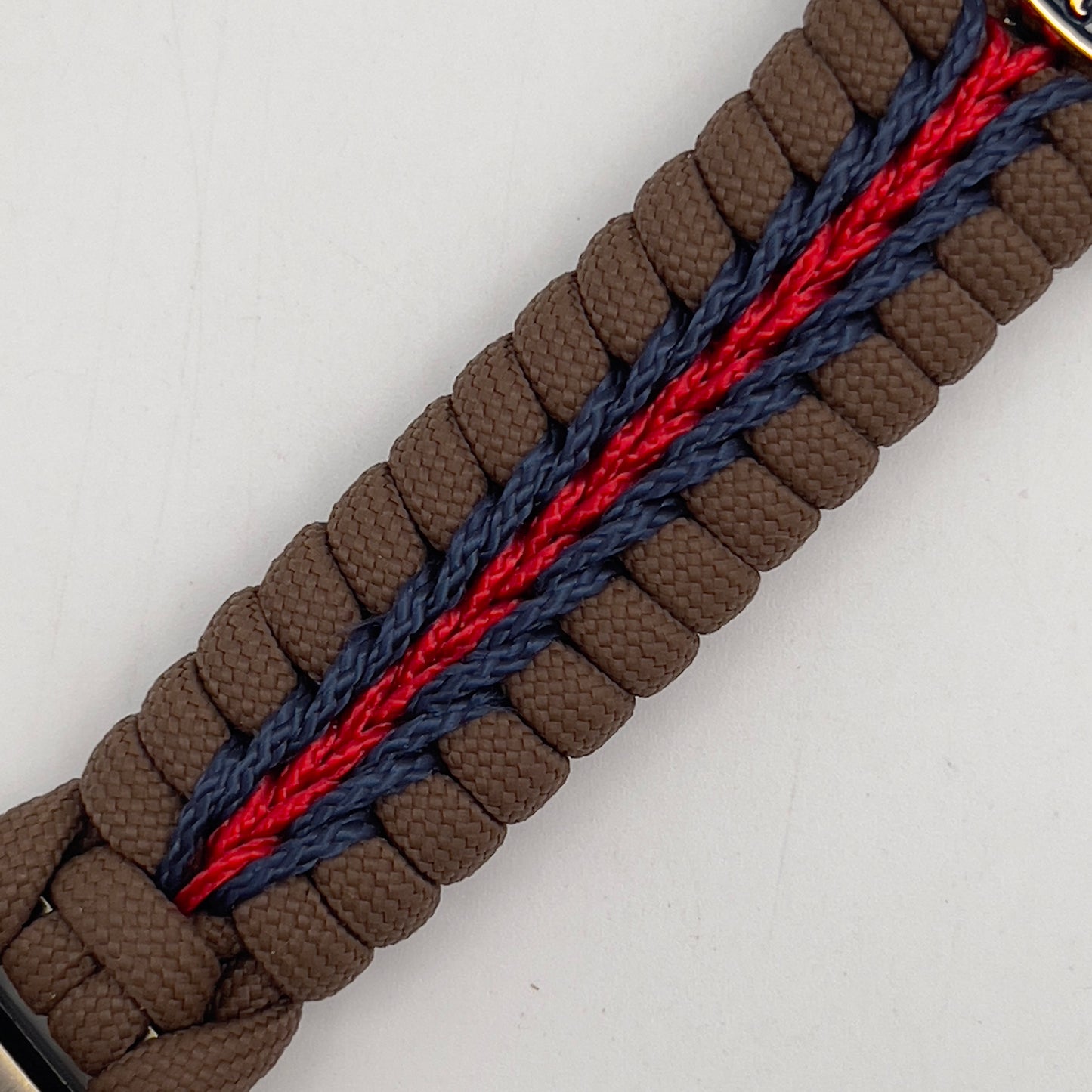 Thick, semi-rigid and comfortable braided United States Marine Corps bracelet featuring a 24K gold and silver plated USMC officer Eagle Globe and Anchor medallion, a Cobra style tactical buckle and woven with Coyote brown 550, Navy blue and Imperial red micro paracord.