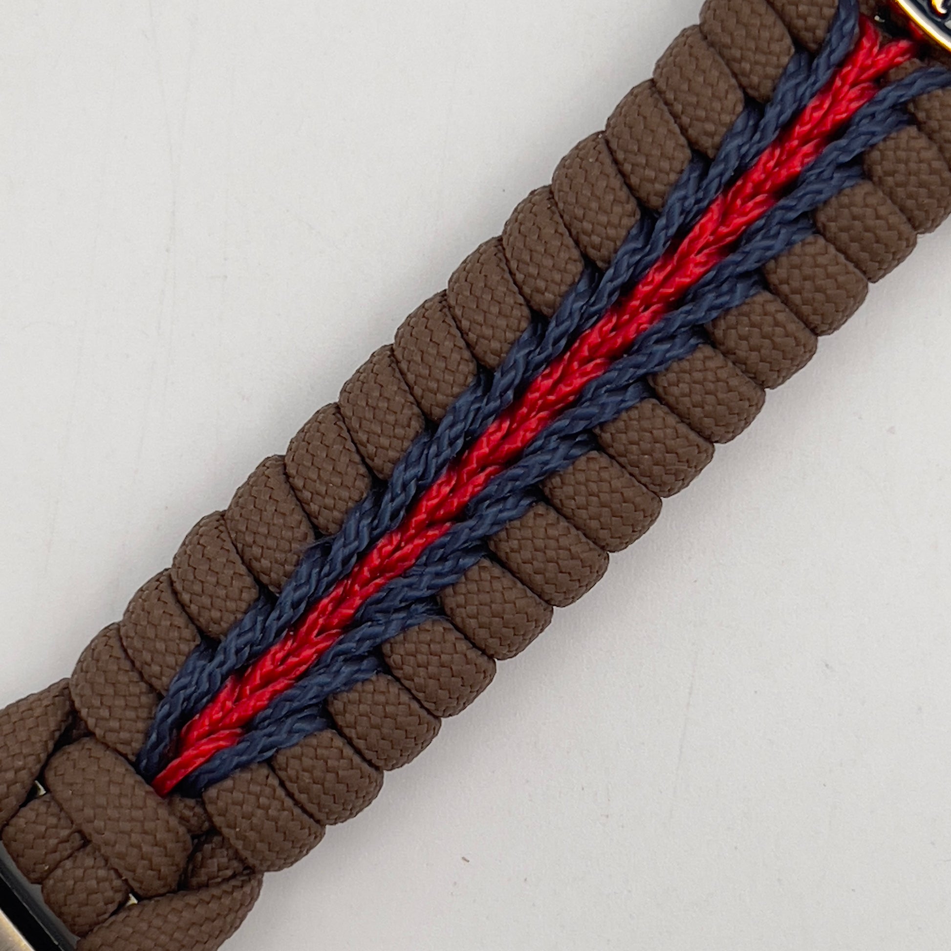 Thick, semi-rigid and comfortable braided United States Marine Corps bracelet featuring a 24K gold and silver plated USMC officer Eagle Globe and Anchor medallion, a Cobra style tactical buckle and woven with Coyote brown 550, Navy blue and Imperial red micro paracord.