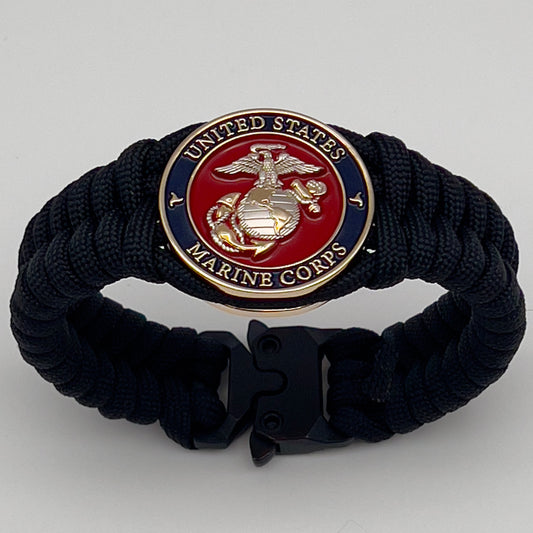 Thick, semi-rigid and comfortable braided United States Marine Corps bracelet featuring a 24K gold and silver plated USMC officer Eagle Globe and Anchor medallion, a black Cobra style tactical buckle and woven with black 550 paracord.