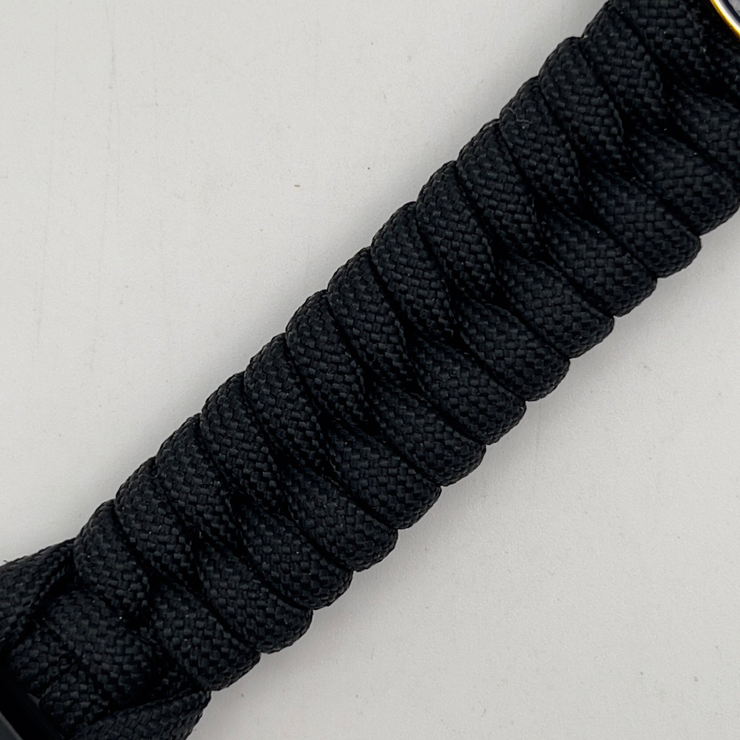 Thick, semi-rigid and comfortable braided United States Marine Corps bracelet featuring a 24K gold and silver plated USMC officer Eagle Globe and Anchor medallion, a black Cobra style tactical buckle and woven with black 550 paracord.