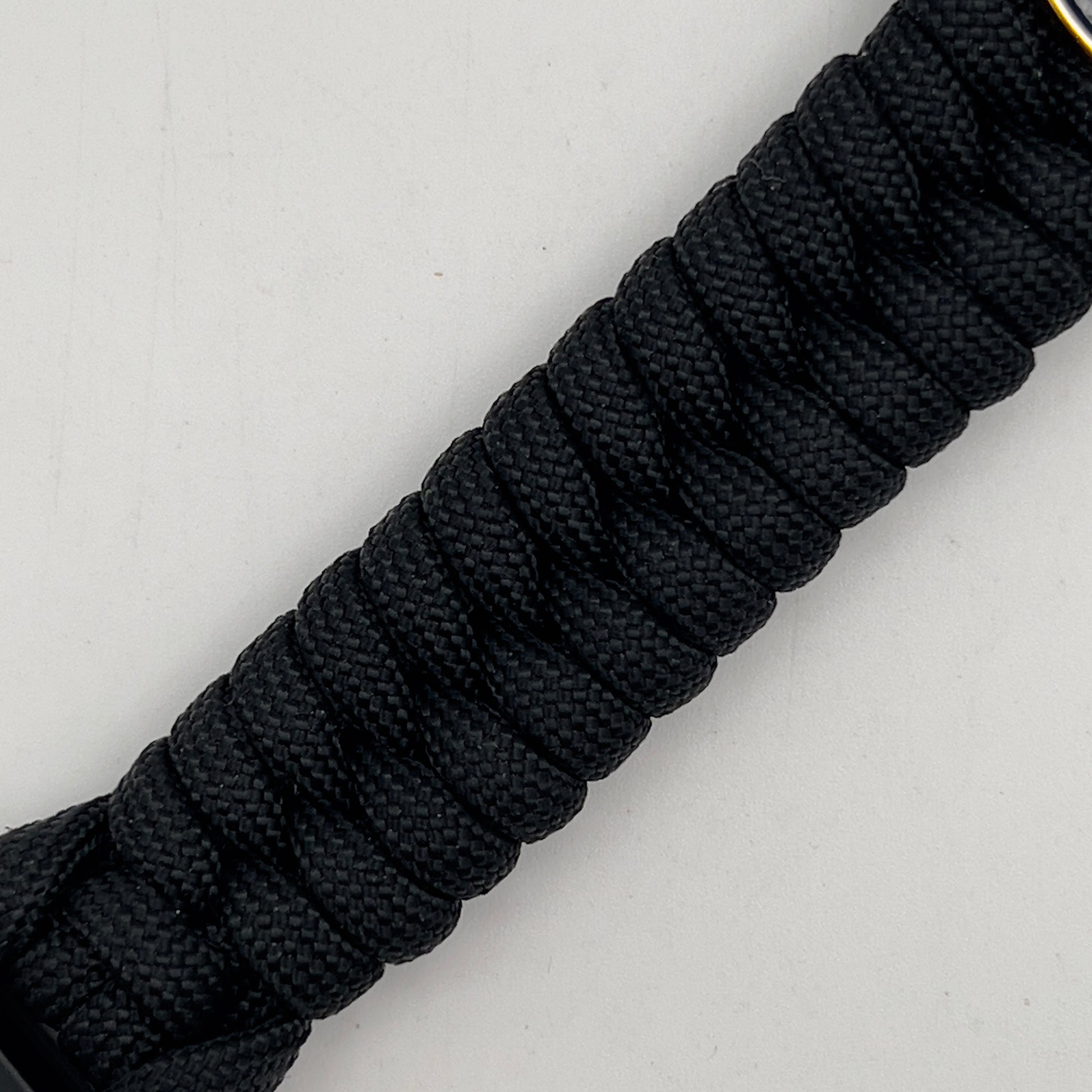 Thick, semi-rigid and comfortable braided United States Marine Corps bracelet featuring a 24K gold and silver plated USMC officer Eagle Globe and Anchor medallion, a black Cobra style tactical buckle and woven with black 550 paracord.