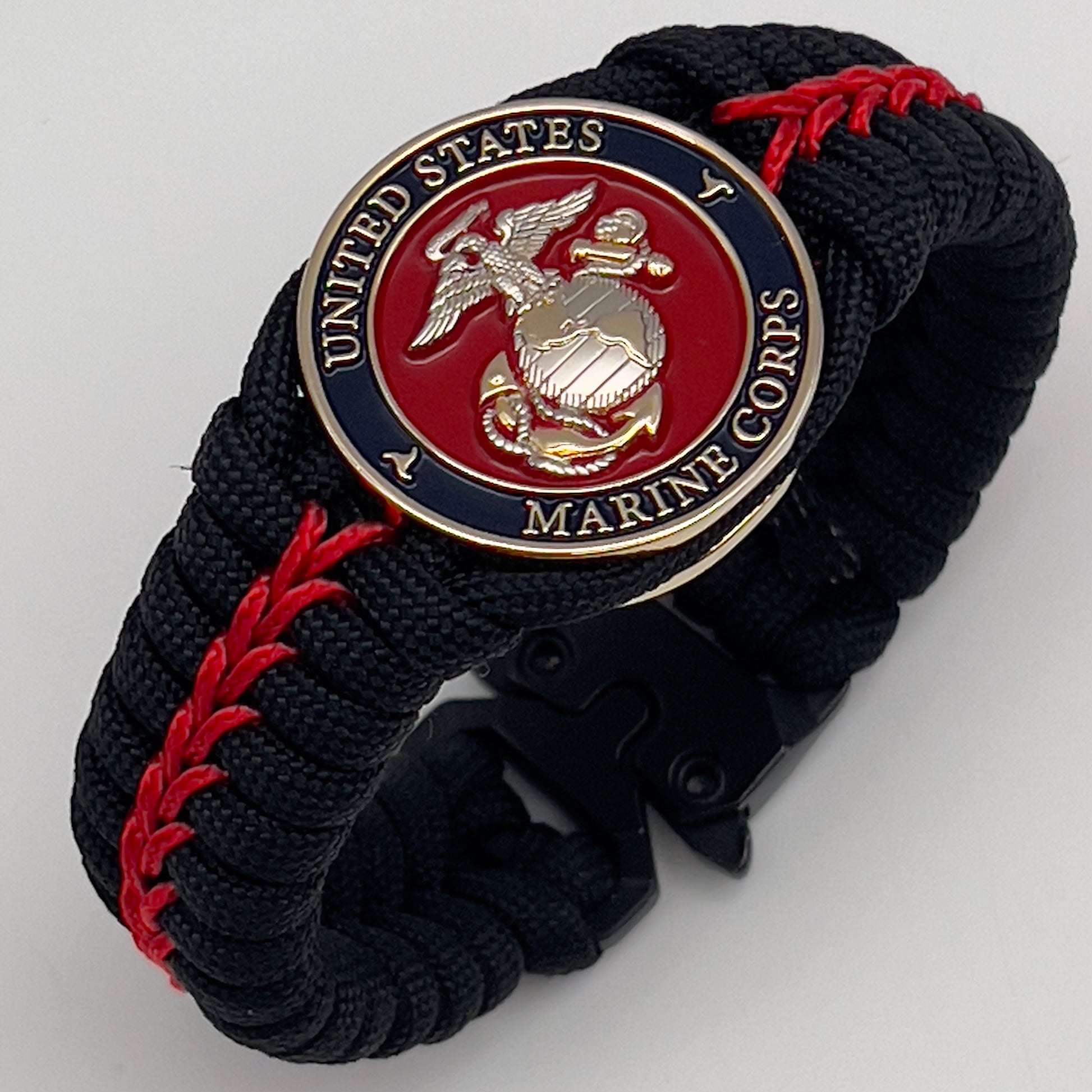Thick, semi-rigid and comfortable braided United States Marine Corps bracelet featuring a 24K gold and silver plated USMC officer Eagle Globe and Anchor medallion, a black Cobra style tactical buckle and woven with black 550 and Imperial red micro paracord.