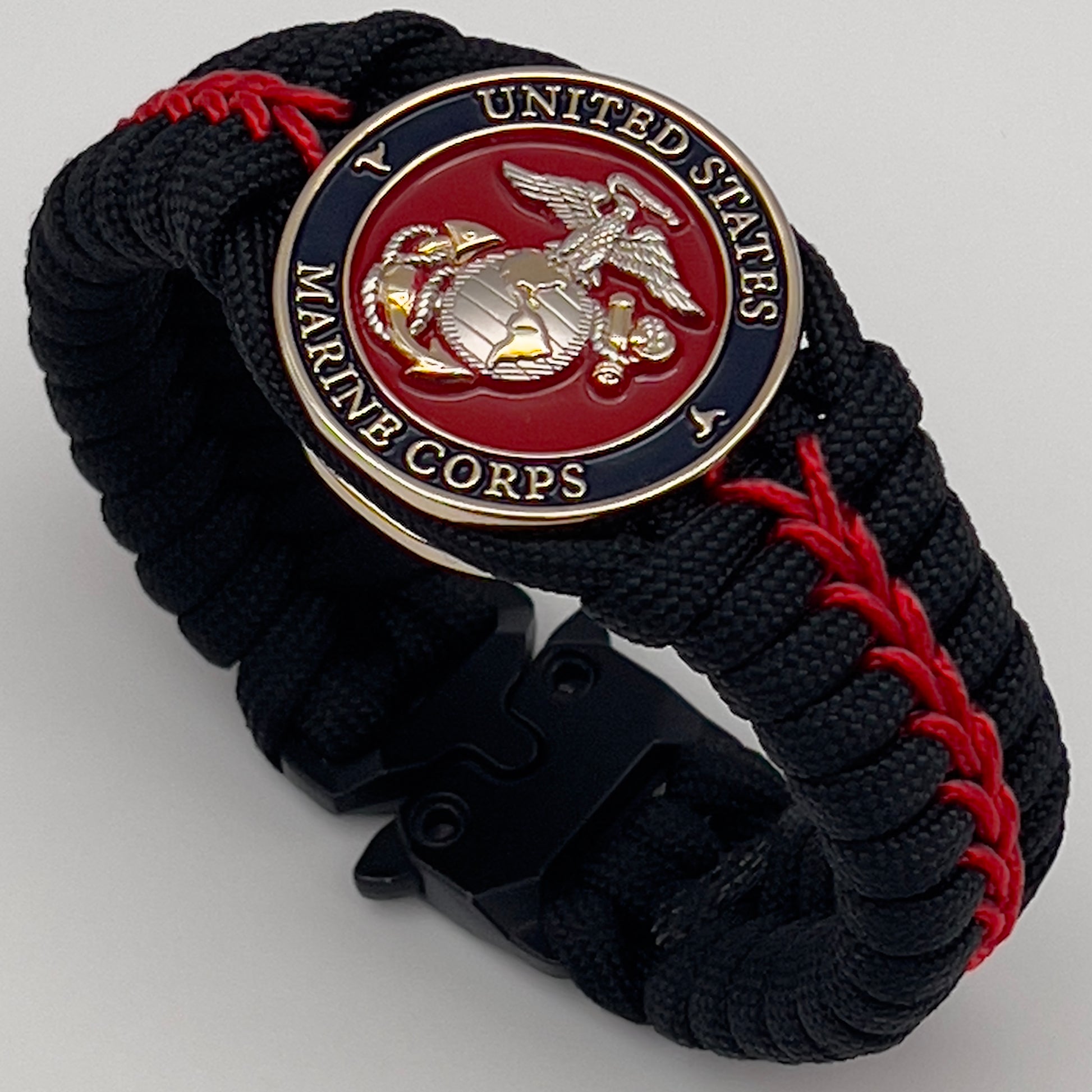 Thick, semi-rigid and comfortable braided United States Marine Corps bracelet featuring a 24K gold and silver plated USMC officer Eagle Globe and Anchor medallion, a black Cobra style tactical buckle and woven with black 550 and Imperial red micro paracord.