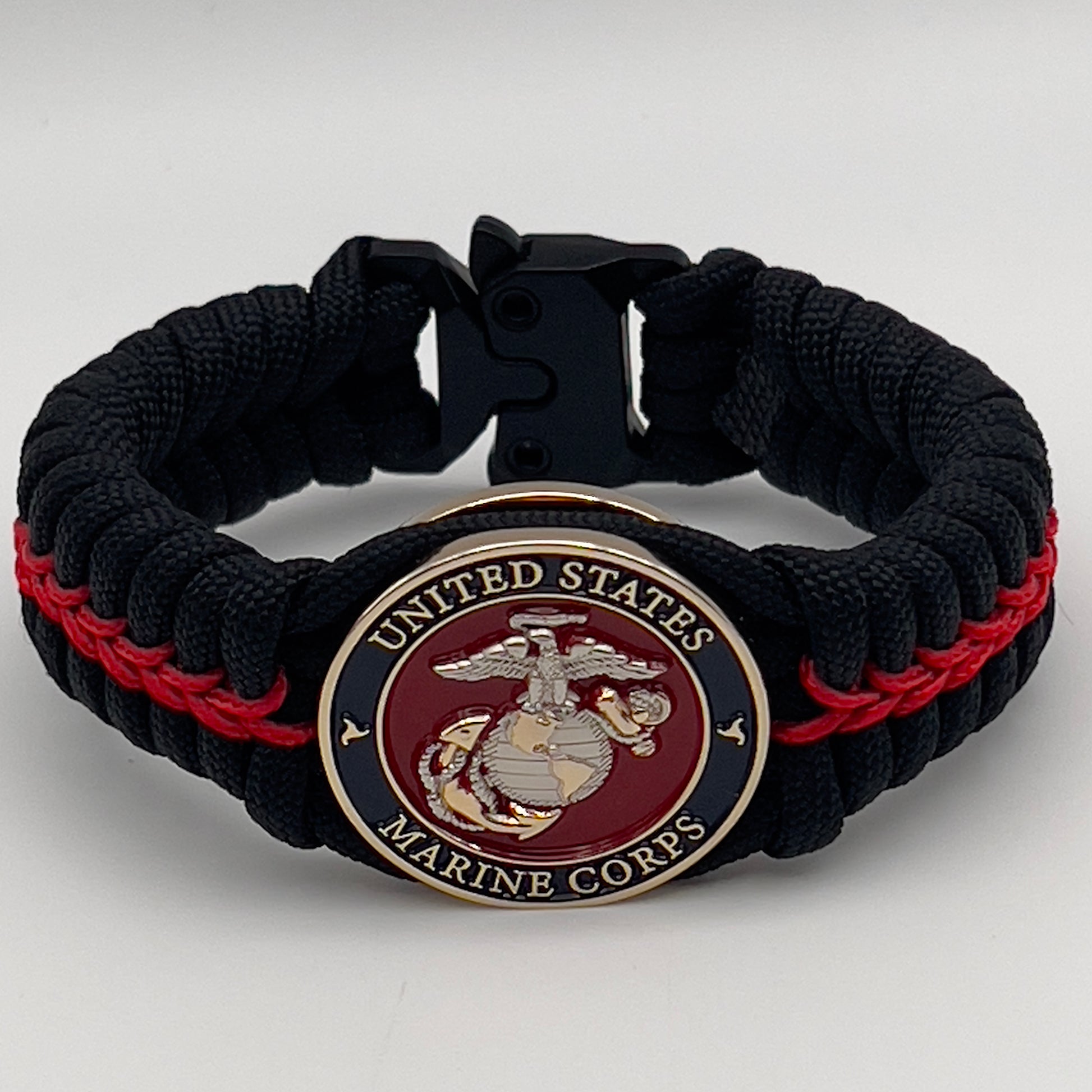 Thick, semi-rigid and comfortable braided United States Marine Corps bracelet featuring a 24K gold and silver plated USMC officer Eagle Globe and Anchor medallion, a black Cobra style tactical buckle and woven with black 550 and Imperial red micro paracord.