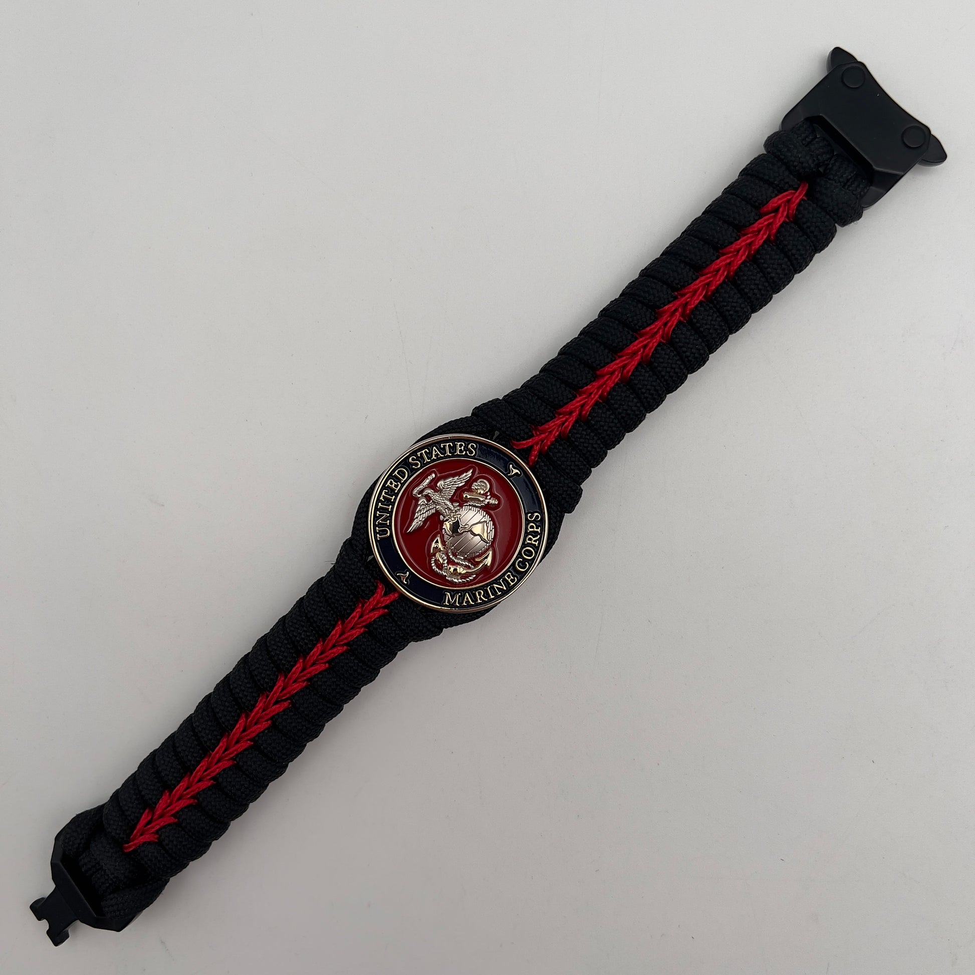 Thick, semi-rigid and comfortable braided United States Marine Corps bracelet featuring a 24K gold and silver plated USMC officer Eagle Globe and Anchor medallion, a black Cobra style tactical buckle and woven with black 550 and Imperial red micro paracord.