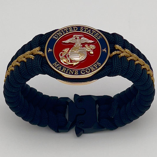 Thick, semi-rigid and comfortable braided United States Marine Corps bracelet featuring a 24K gold and silver plated USMC officer Eagle Globe and Anchor medallion, a black Cobra style tactical buckle and woven with black 550 and gold micro paracord.