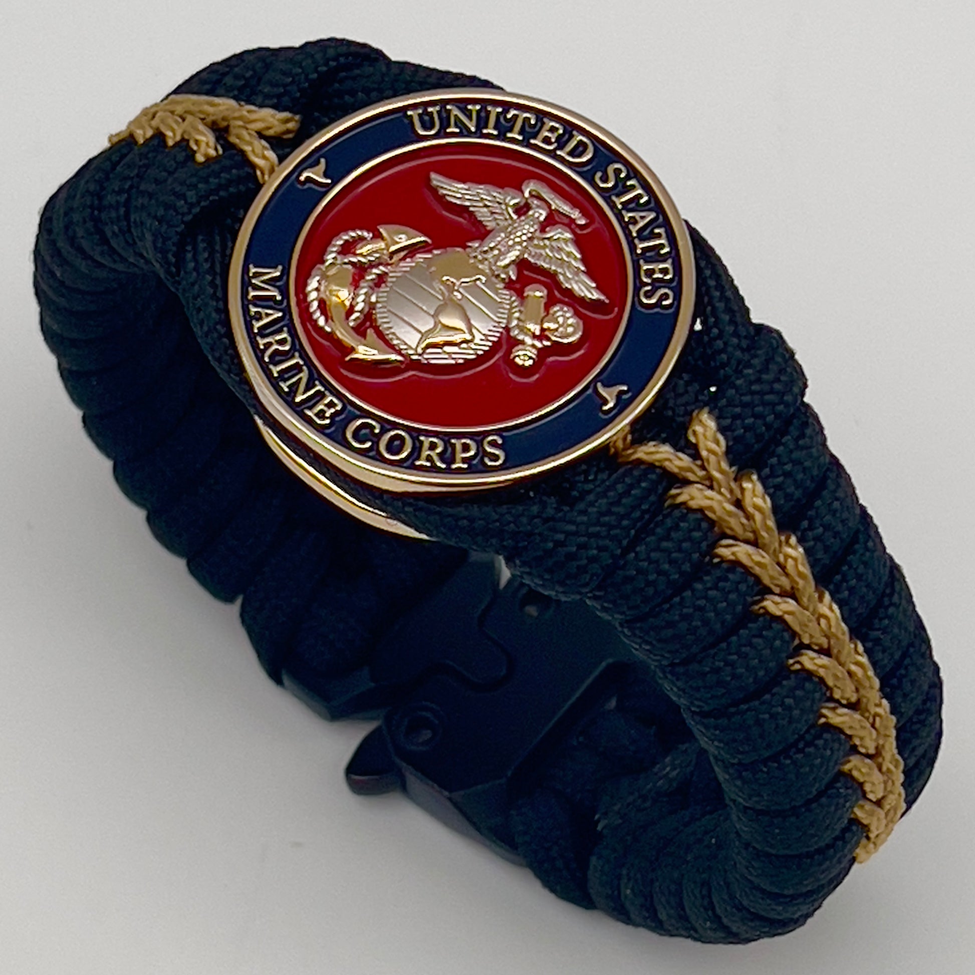 Thick, semi-rigid and comfortable braided United States Marine Corps bracelet featuring a 24K gold and silver plated USMC officer Eagle Globe and Anchor medallion, a black Cobra style tactical buckle and woven with black 550 and gold micro paracord.