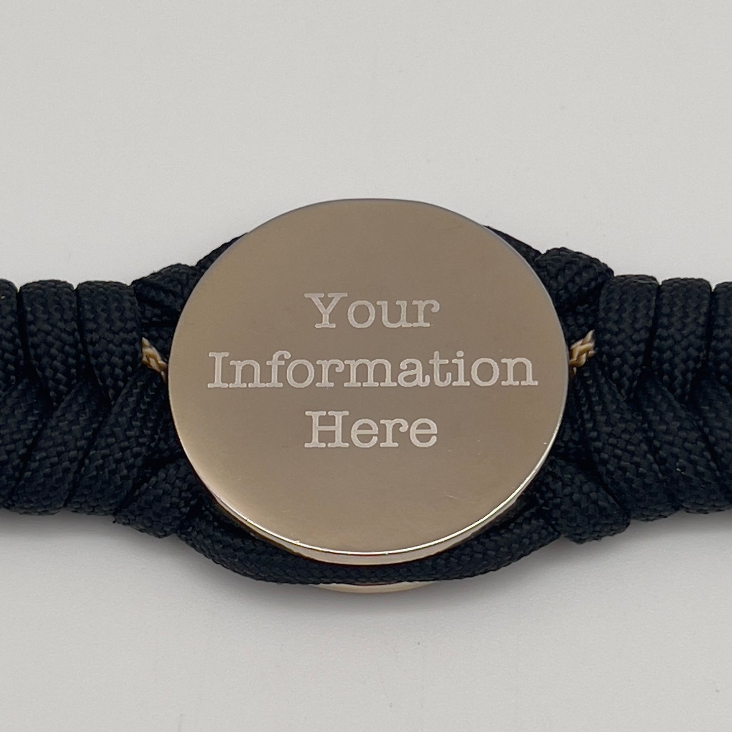 Thick, semi-rigid and comfortable braided United States Marine Corps bracelet featuring a 24K gold and silver plated USMC officer Eagle Globe and Anchor medallion, a black Cobra style tactical buckle and woven with black 550 and gold micro paracord.