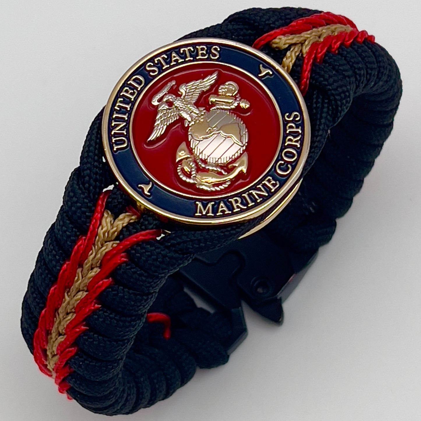 Thick, semi-rigid and comfortable braided United States Marine Corps bracelet featuring a 24K gold and silver plated USMC officer Eagle Globe and Anchor medallion, a black Cobra style tactical buckle and woven with black 550, Imperial red and gold micro paracord.