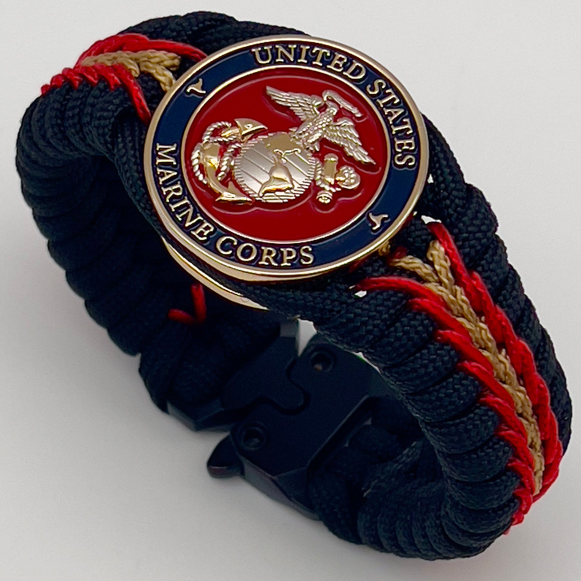 Thick, semi-rigid and comfortable braided United States Marine Corps bracelet featuring a 24K gold and silver plated USMC officer Eagle Globe and Anchor medallion, a black Cobra style tactical buckle and woven with black 550, Imperial red and gold micro paracord.