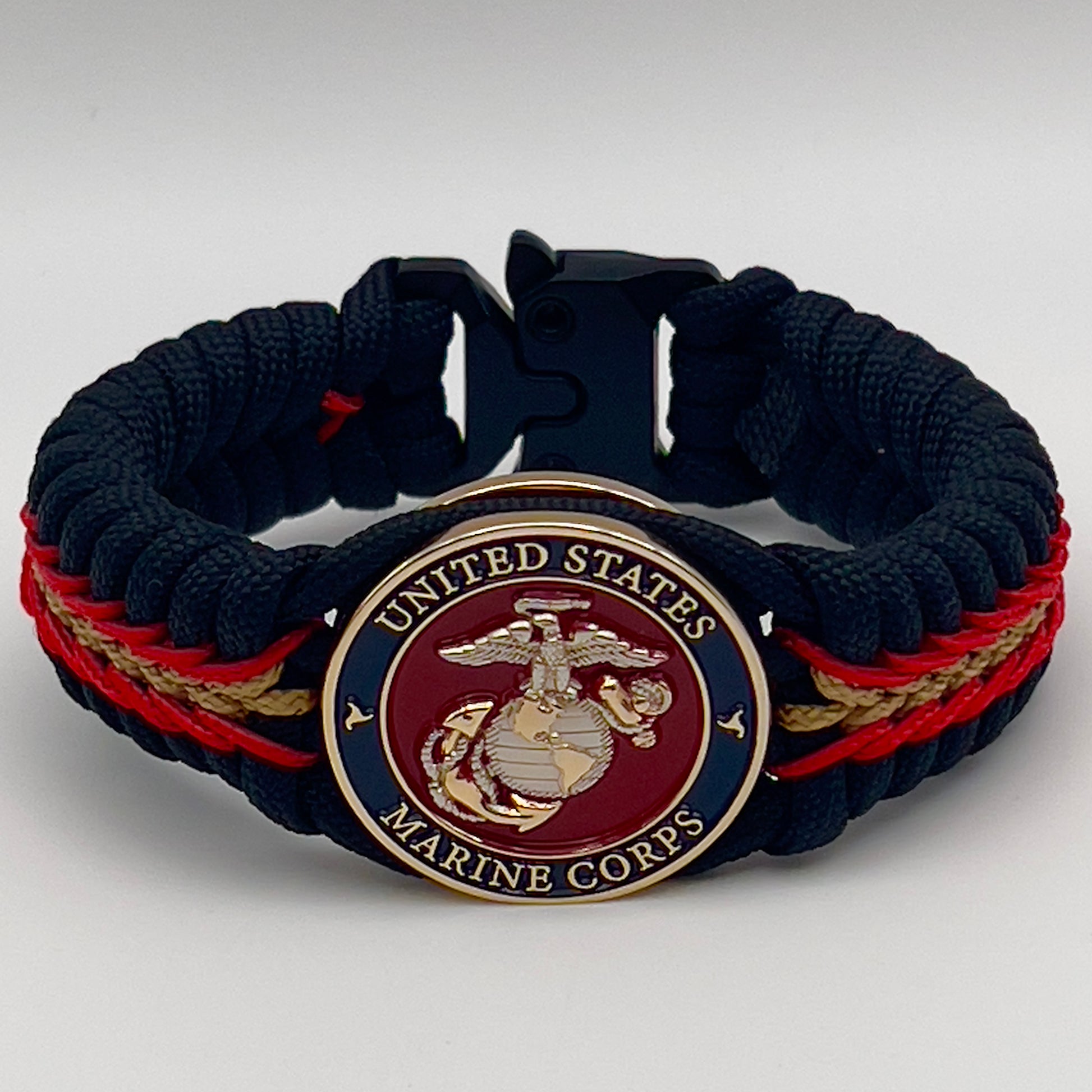 Thick, semi-rigid and comfortable braided United States Marine Corps bracelet featuring a 24K gold and silver plated USMC officer Eagle Globe and Anchor medallion, a black Cobra style tactical buckle and woven with black 550, Imperial red and gold micro paracord.