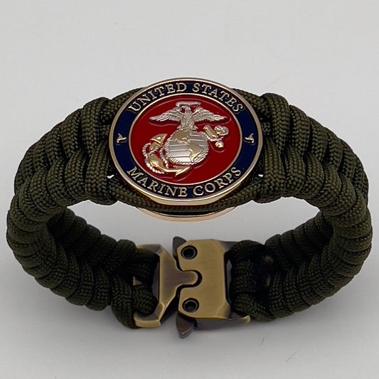 Thick, semi-rigid and comfortable braided United States Marine Corps bracelet featuring a 24K gold and silver plated USMC officer Eagle Globe and Anchor medallion, a gold Cobra style tactical buckle and woven with olive drab 550 paracord.