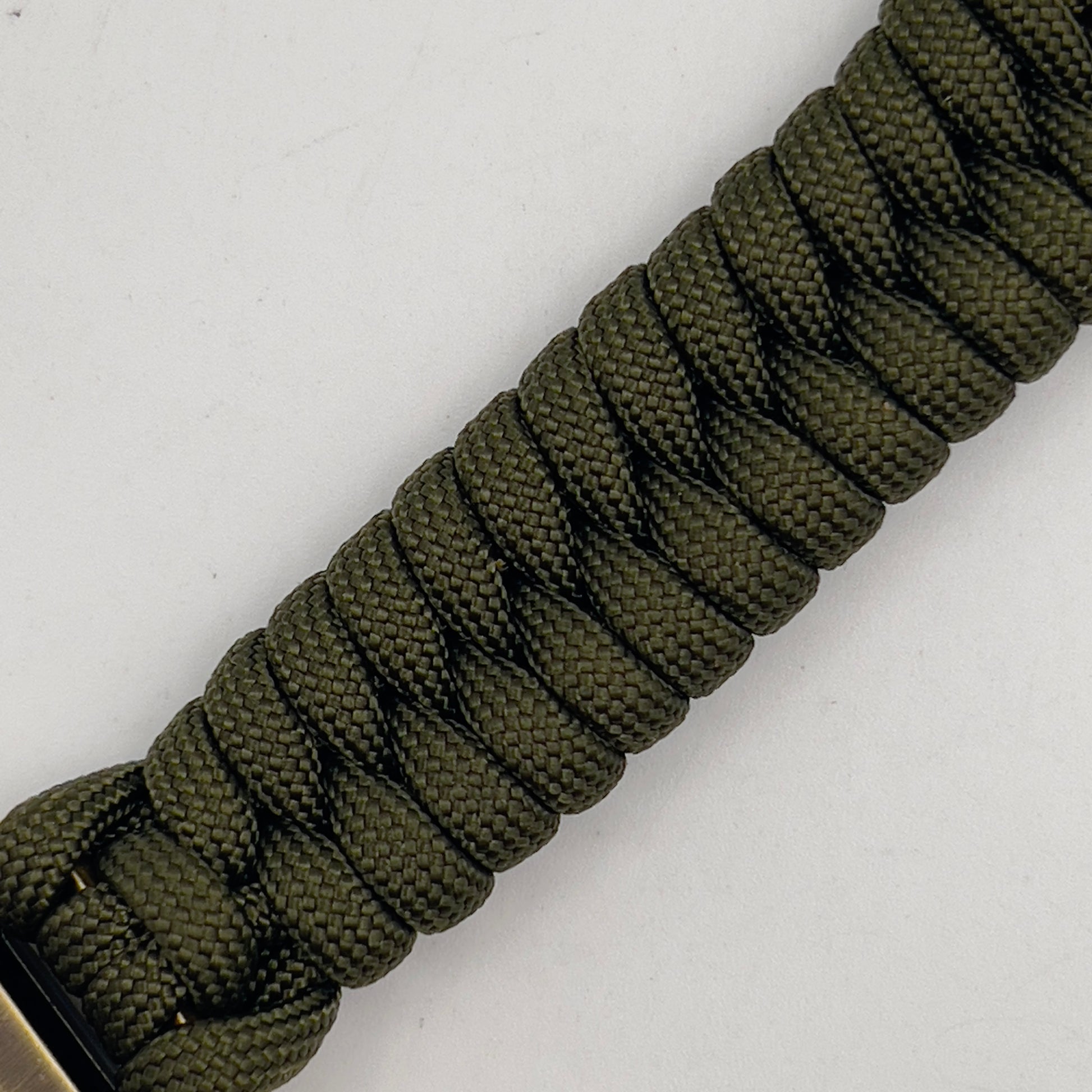 Thick, semi-rigid and comfortable braided United States Marine Corps bracelet featuring a 24K gold and silver plated USMC officer Eagle Globe and Anchor medallion, a gold Cobra style tactical buckle and woven with olive drab 550 paracord.