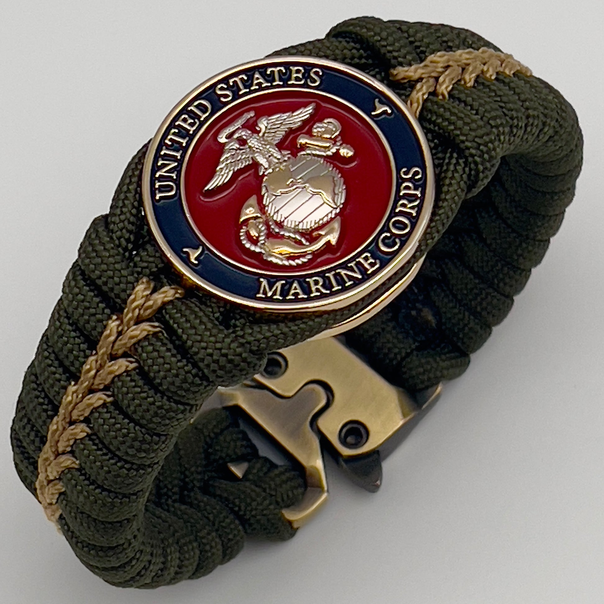 Thick, semi-rigid and comfortable braided United States Marine Corps bracelet featuring a 24K gold and silver plated USMC officer Eagle Globe and Anchor medallion, a gold Cobra style tactical buckle and woven with olive drab 550 and gold micro paracord.