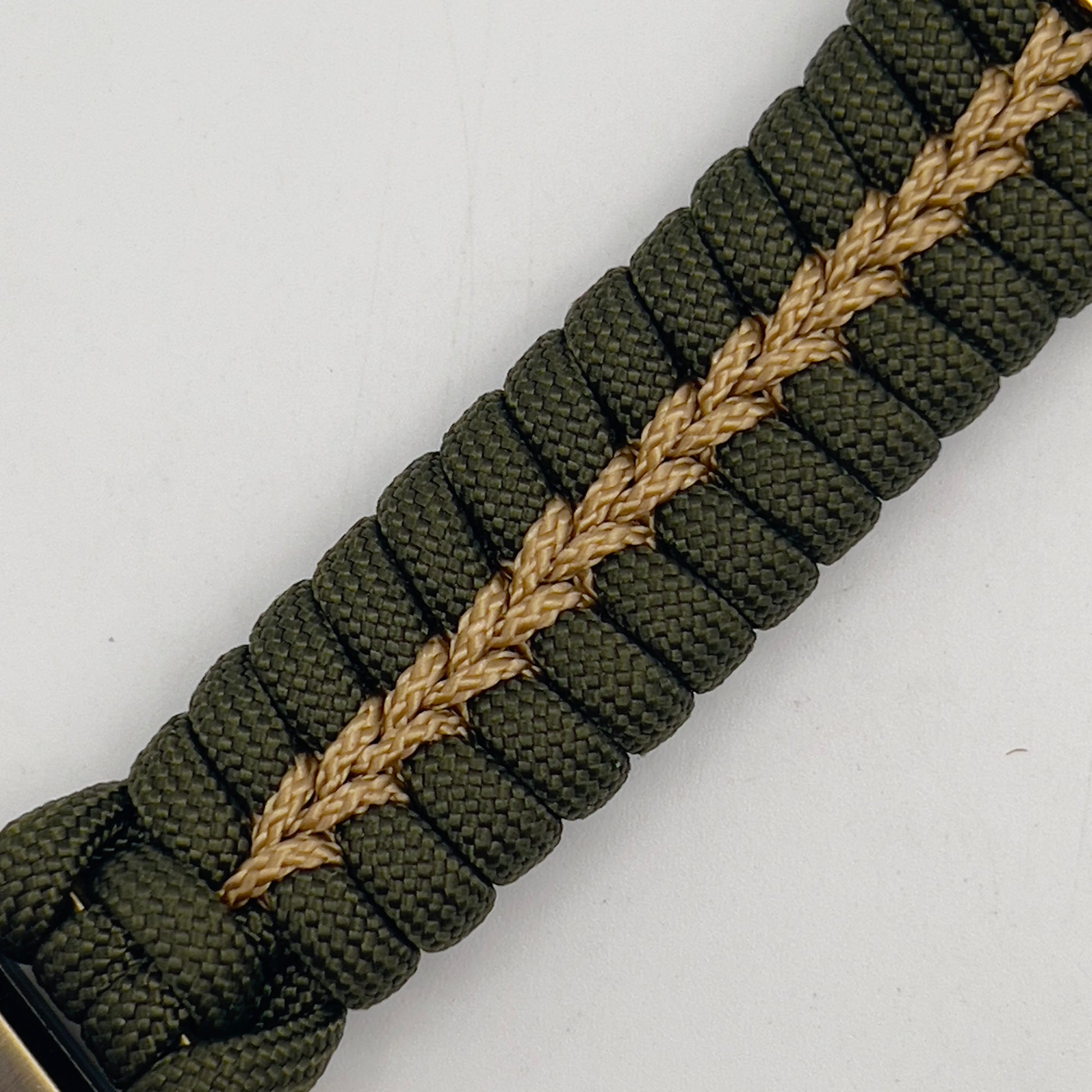 Thick, semi-rigid and comfortable braided United States Marine Corps bracelet featuring a 24K gold and silver plated USMC officer Eagle Globe and Anchor medallion, a gold Cobra style tactical buckle and woven with olive drab 550 and gold micro paracord.