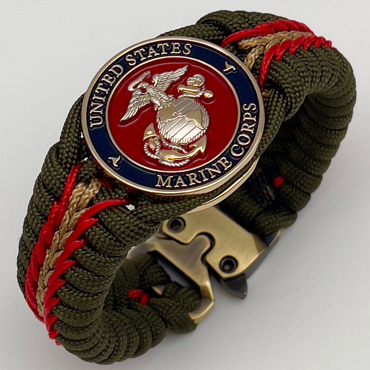 Thick, semi-rigid and comfortable braided United States Marine Corps bracelet featuring a 24K gold and silver plated USMC officer Eagle Globe and Anchor medallion, a gold Cobra style tactical buckle and woven with olive drab 550 and gold micro paracord.