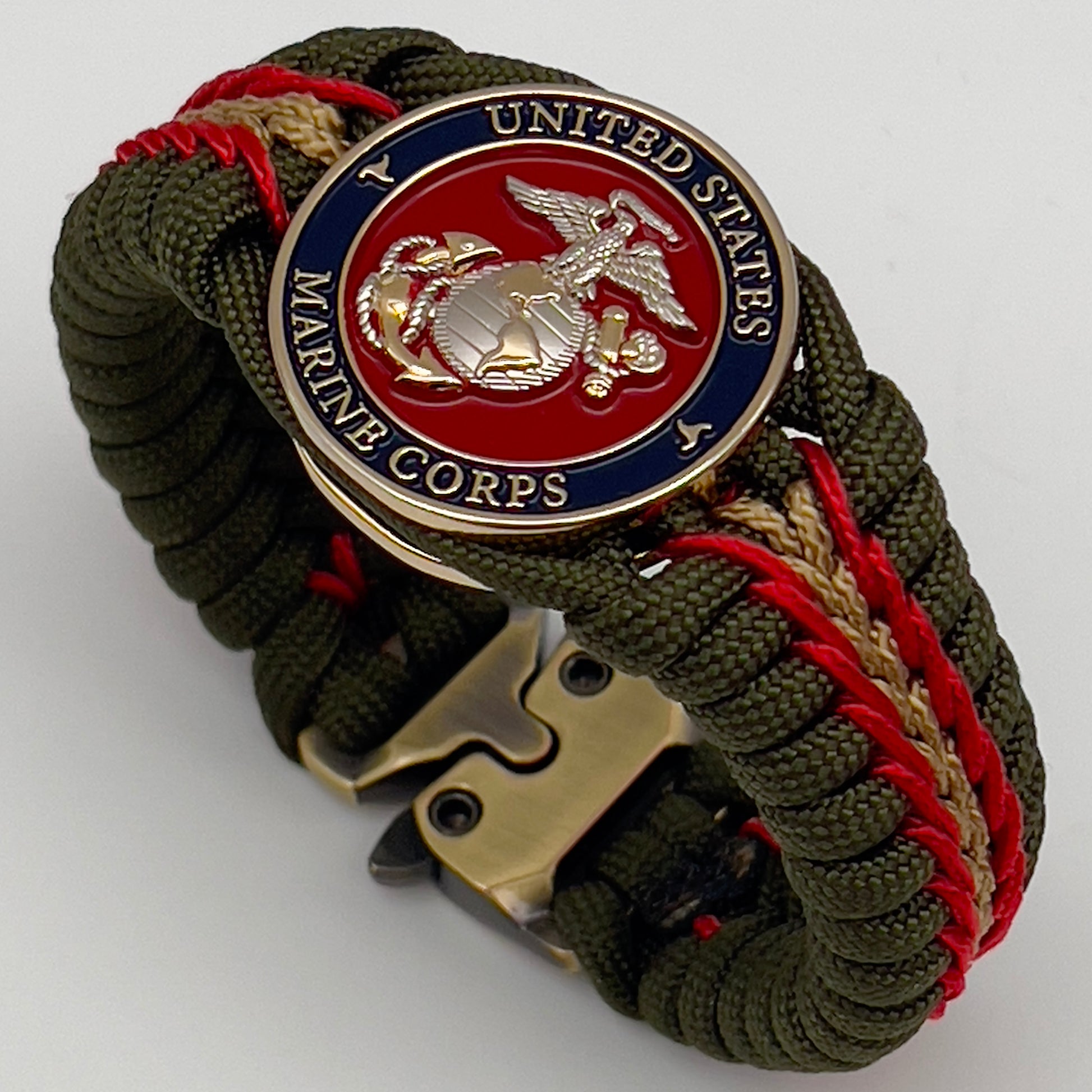 Thick, semi-rigid and comfortable braided United States Marine Corps bracelet featuring a 24K gold and silver plated USMC officer Eagle Globe and Anchor medallion, a gold Cobra style tactical buckle and woven with olive drab 550 and gold micro paracord.