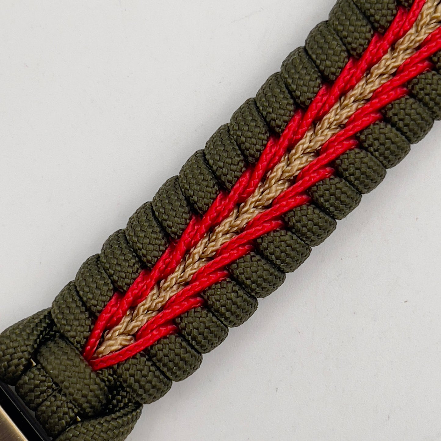 Thick, semi-rigid and comfortable braided United States Marine Corps bracelet featuring a 24K gold and silver plated USMC officer Eagle Globe and Anchor medallion, a gold Cobra style tactical buckle and woven with olive drab 550 and gold micro paracord.