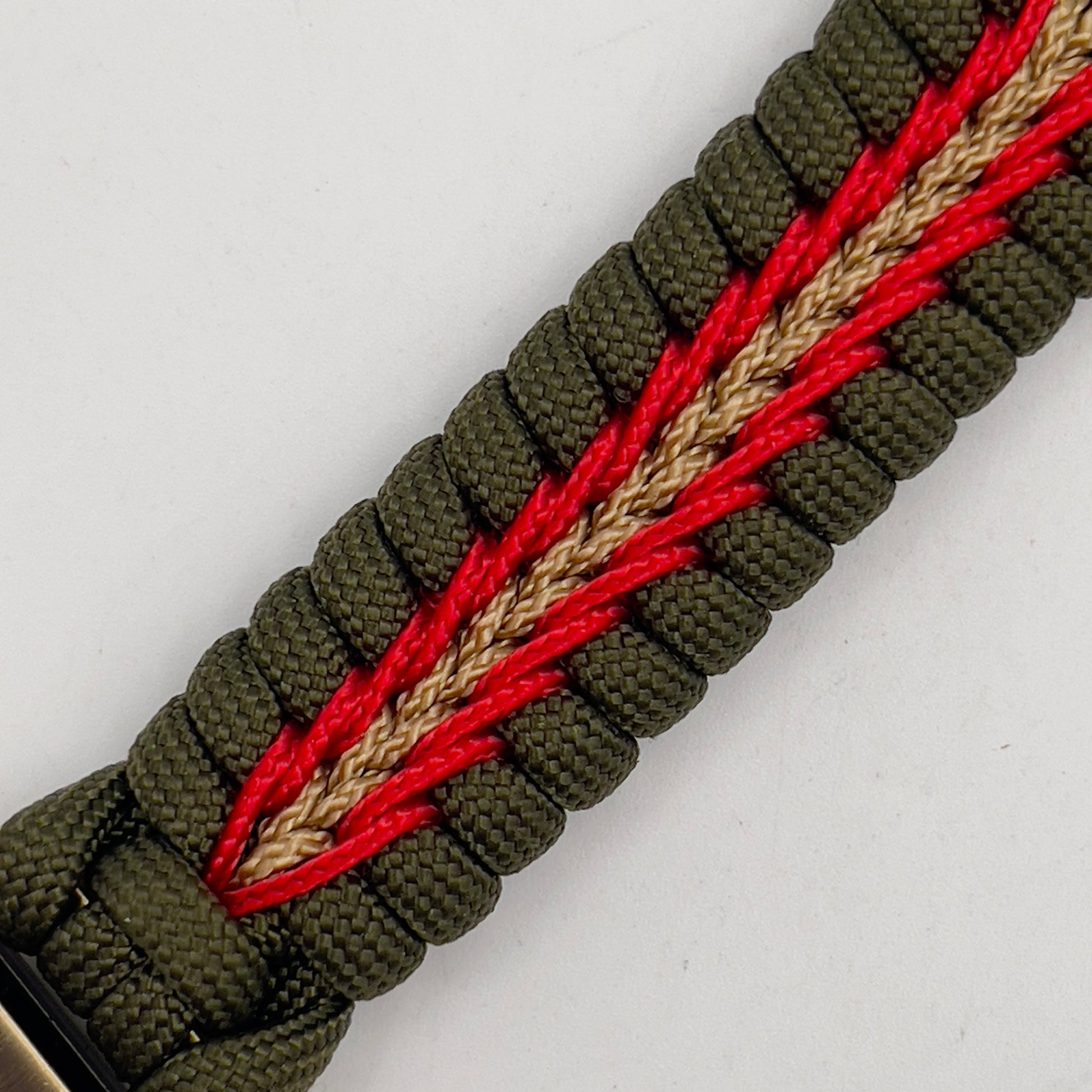 Thick, semi-rigid and comfortable braided United States Marine Corps bracelet featuring a 24K gold and silver plated USMC officer Eagle Globe and Anchor medallion, a gold Cobra style tactical buckle and woven with olive drab 550 and gold micro paracord.