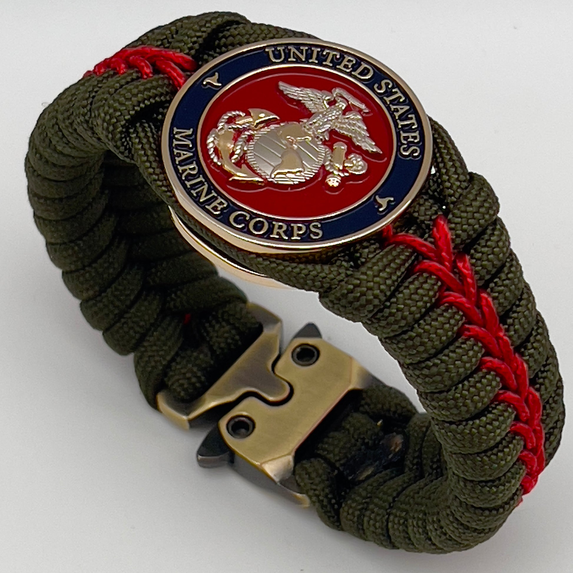Thick, semi-rigid and comfortable braided United States Marine Corps bracelet featuring a 24K gold and silver plated USMC officer Eagle Globe and Anchor medallion, a gold Cobra style tactical buckle and woven with olive drab 550 and Imperial red micro paracord.