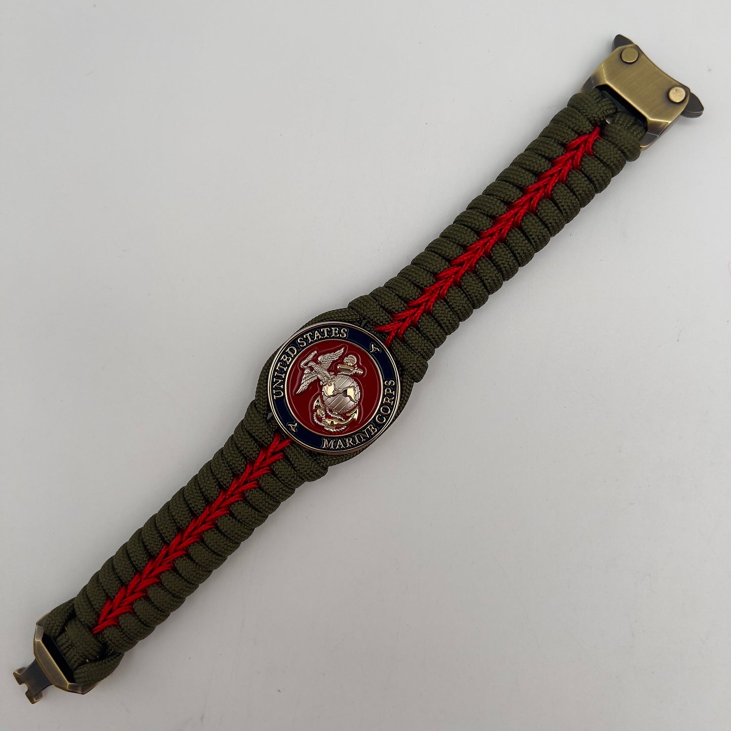 Thick, semi-rigid and comfortable braided United States Marine Corps bracelet featuring a 24K gold and silver plated USMC officer Eagle Globe and Anchor medallion, a gold Cobra style tactical buckle and woven with olive drab 550 and Imperial red micro paracord.