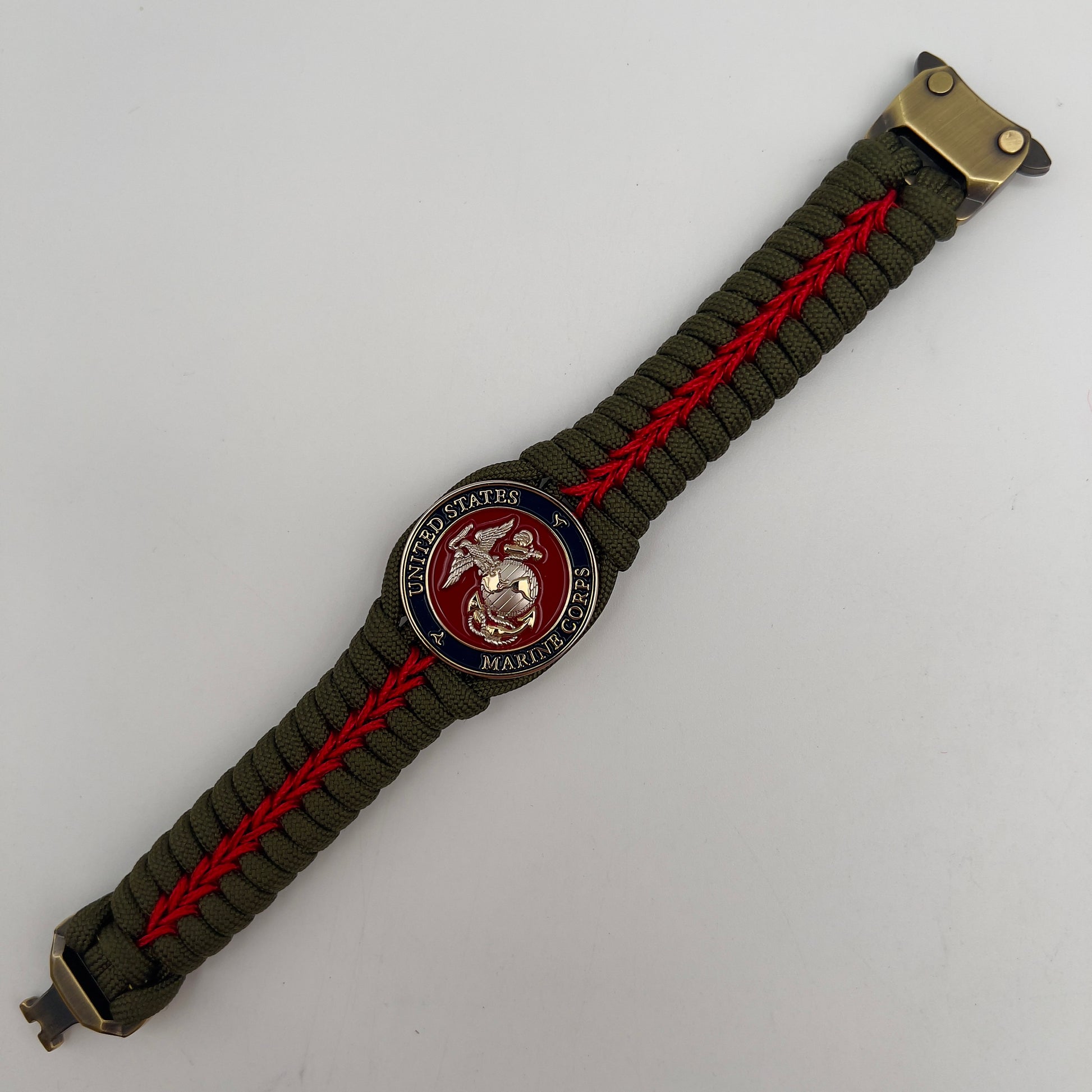Thick, semi-rigid and comfortable braided United States Marine Corps bracelet featuring a 24K gold and silver plated USMC officer Eagle Globe and Anchor medallion, a gold Cobra style tactical buckle and woven with olive drab 550 and Imperial red micro paracord.