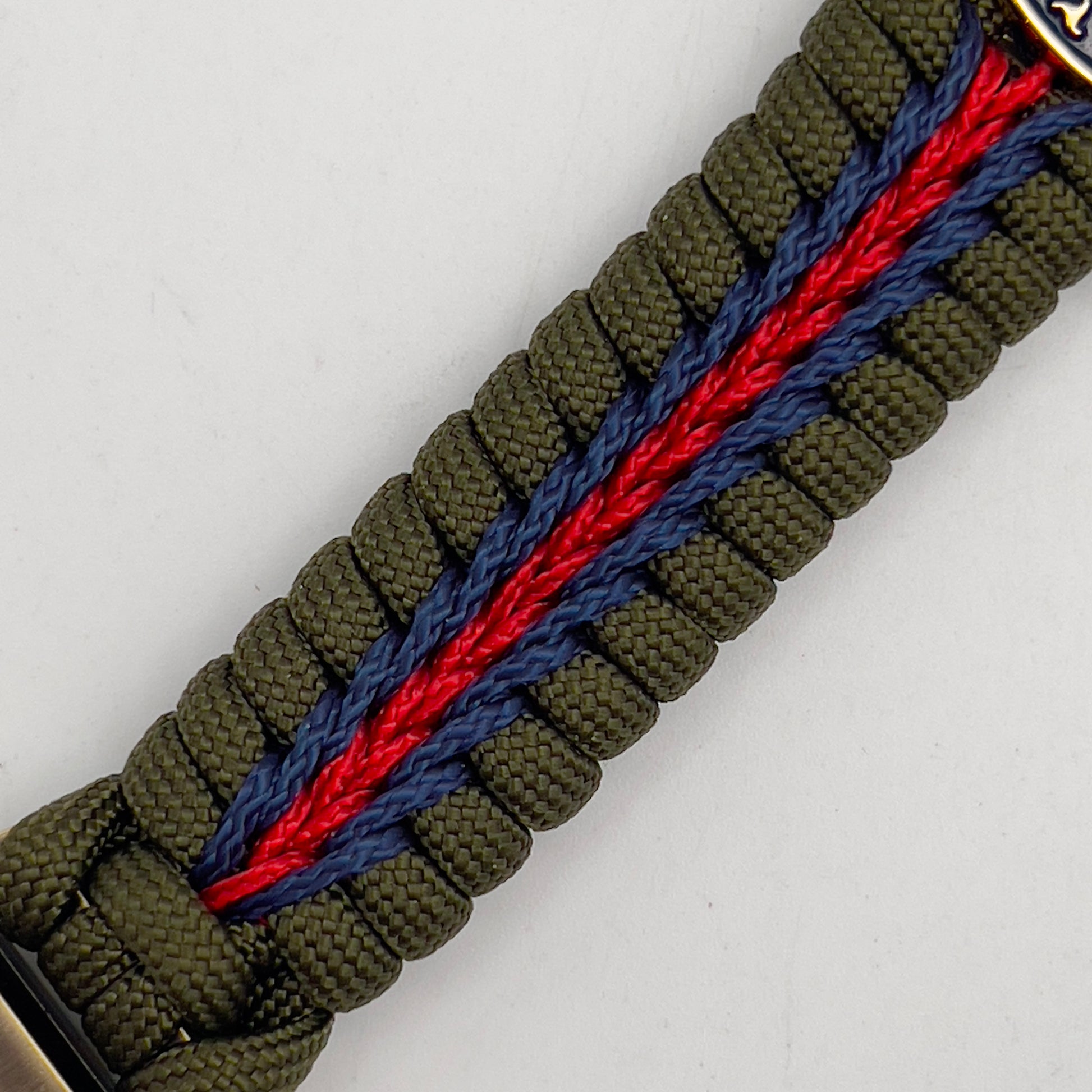 Thick, semi-rigid and comfortable braided United States Marine Corps bracelet featuring a 24K gold and silver plated USMC officer Eagle Globe and Anchor medallion, a gold Cobra style tactical buckle and woven with olive drab 550 and Imperial red and gold micro paracord.