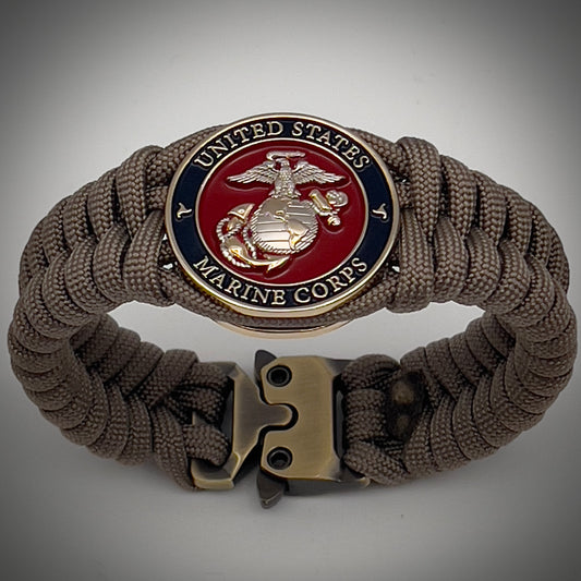 Thick, semi-rigid and comfortable braided United States Marine Corps bracelet featuring a 24K gold and silver plated USMC officer Eagle Globe and Anchor medallion, a gold Cobra style tactical buckle and woven with tan 550 paracord.