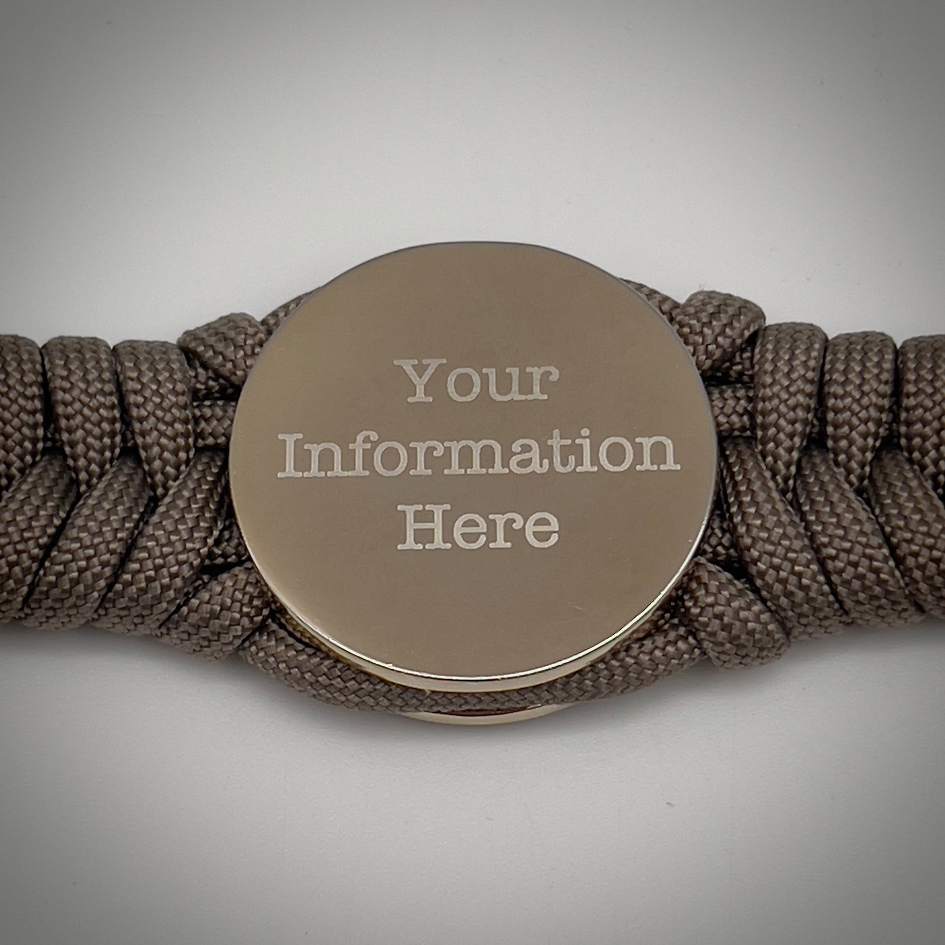Thick, semi-rigid and comfortable braided United States Marine Corps bracelet featuring a 24K gold and silver plated USMC officer Eagle Globe and Anchor medallion, a gold Cobra style tactical buckle and woven with tan 550 paracord.