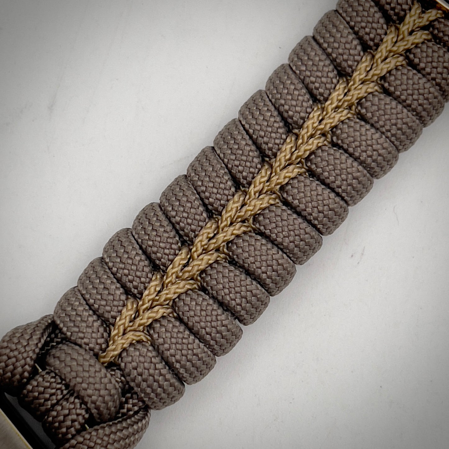 Thick, semi-rigid and comfortable braided United States Marine Corps bracelet featuring a 24K gold and silver plated USMC officer Eagle Globe and Anchor medallion, a gold Cobra style tactical buckle and woven with tan 550 paracord and gold micro cord.
