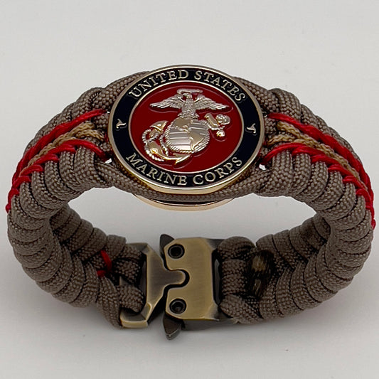 Thick and comfortable braided United States Marine Corps bracelet featuring a 24K gold and silver plated USMC officer Eagle Globe and Anchor medallion, a Cobra style tactical buckle and woven with tan 550, Imperial red and gold micro paracord.