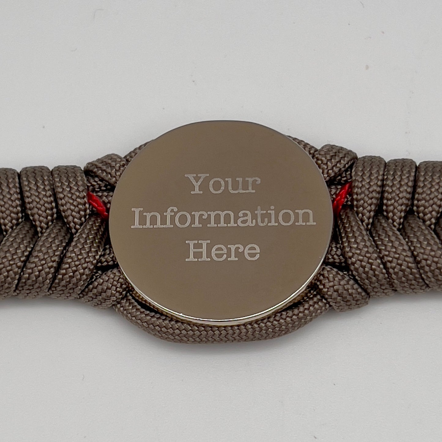 Thick, semi-rigid and comfortable braided United States Marine Corps bracelet featuring a 24K gold and silver plated USMC officer Eagle Globe and Anchor medallion, a gold Cobra style tactical buckle and woven with tan 550 paracord and Imperial red micro cord.