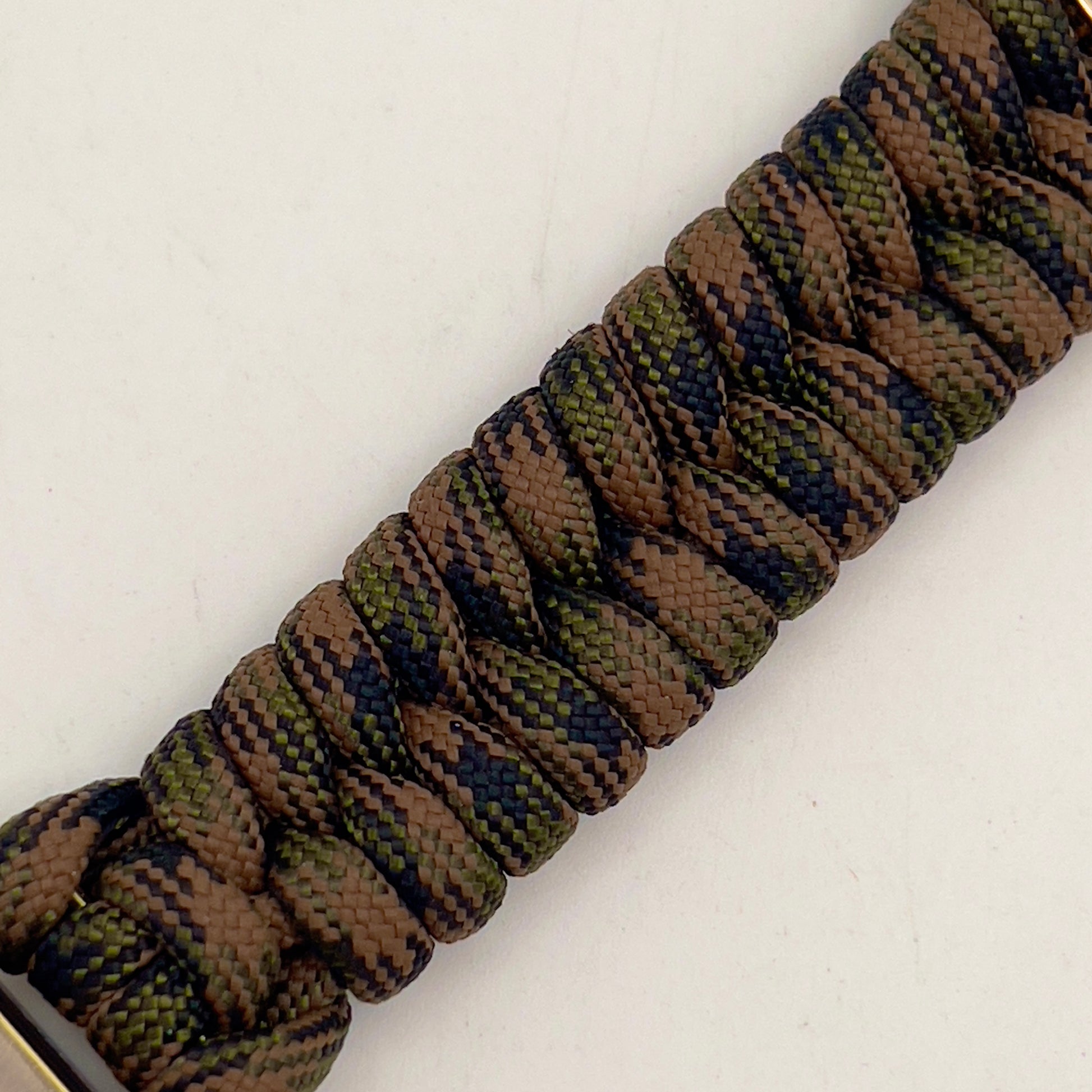 Thick, semi-rigid and comfortable braided United States Marine Corps bracelet featuring a 24K gold and silver plated USMC officer Eagle Globe and Anchor medallion, a gold Cobra style tactical buckle and woven with Woodland Camo 550 paracord.