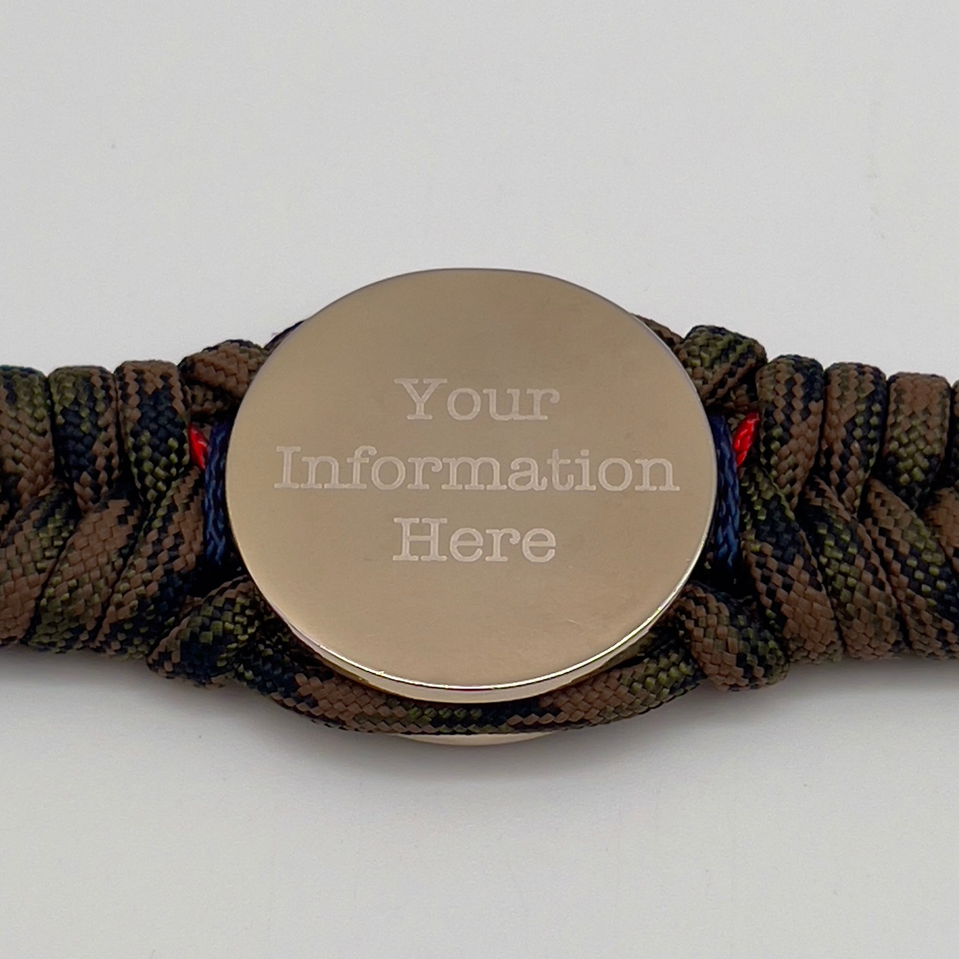 Thick, semi-rigid and comfortable braided United States Marine Corps bracelet featuring a 24K gold and silver plated USMC officer Eagle Globe and Anchor medallion, a gold Cobra style tactical buckle and woven with Woodland Camo 550 paracord and Imperial Red and Navy Blue micro cord.