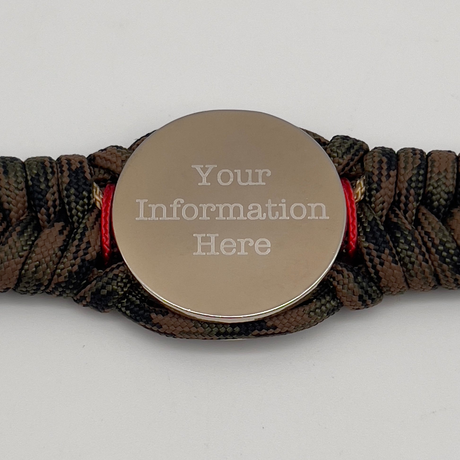 Thick, semi-rigid and comfortable braided United States Marine Corps bracelet featuring a 24K gold and silver plated USMC officer Eagle Globe and Anchor medallion, a gold Cobra style tactical buckle and woven with Woodland Camo 550 paracord and Imperial Red and gold micro cord.