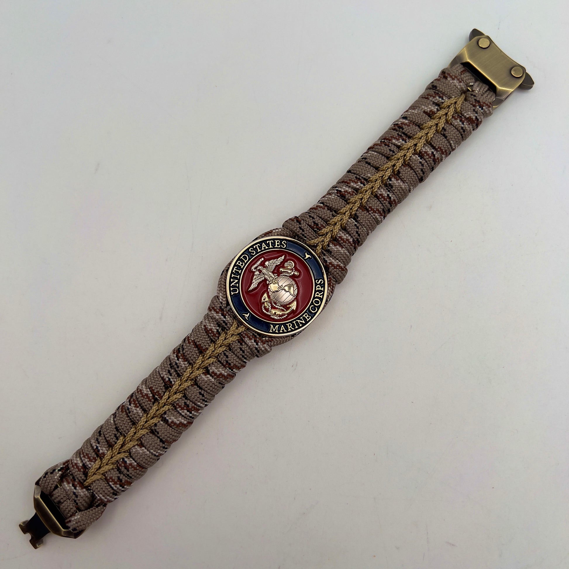 Thick and comfortable braided United States Marine Corps bracelet featuring a 24K gold and silver plated USMC officer Eagle Globe and Anchor medallion, a Cobra style tactical buckle and woven with Desert Camo 550 paracord gold micro cord.