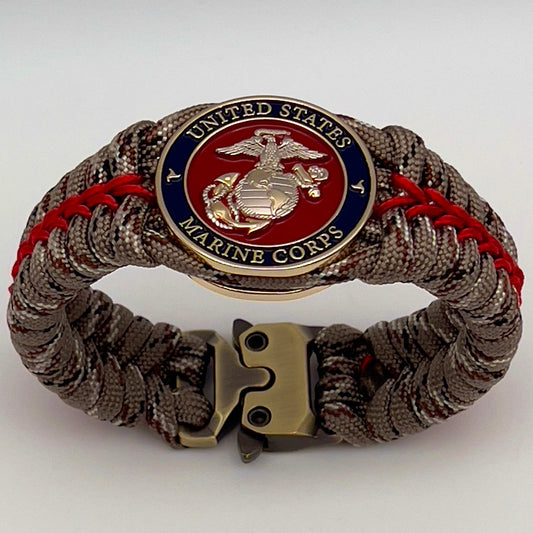 Thick and comfortable braided United States Marine Corps bracelet featuring a 24K gold and silver plated USMC officer Eagle Globe and Anchor medallion, a Cobra style tactical buckle and woven with Desert Camo 550 paracord and Imperial red micro cord.
