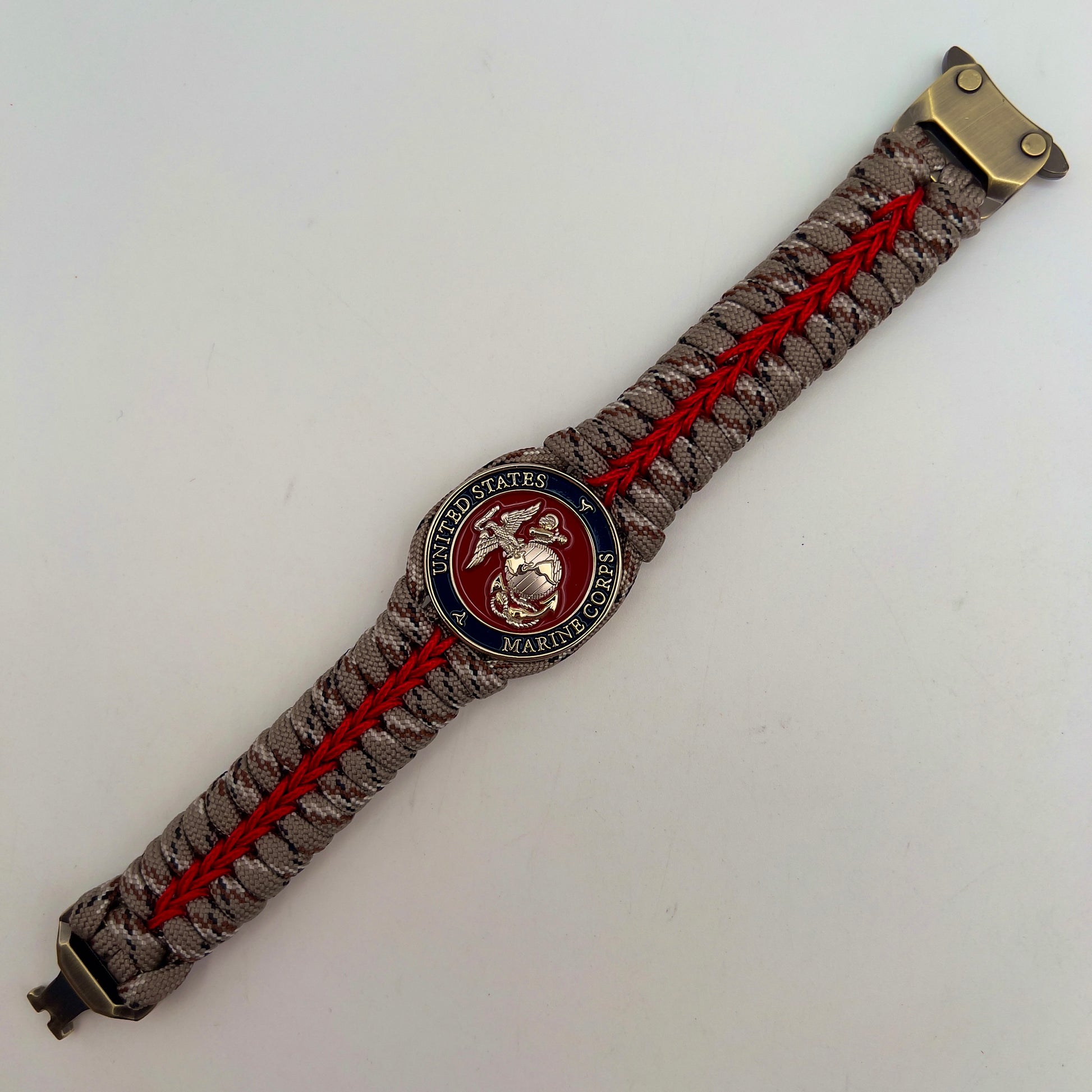 Thick and comfortable braided United States Marine Corps bracelet featuring a 24K gold and silver plated USMC officer Eagle Globe and Anchor medallion, a Cobra style tactical buckle and woven with Desert Camo 550 paracord and Imperial red micro cord.